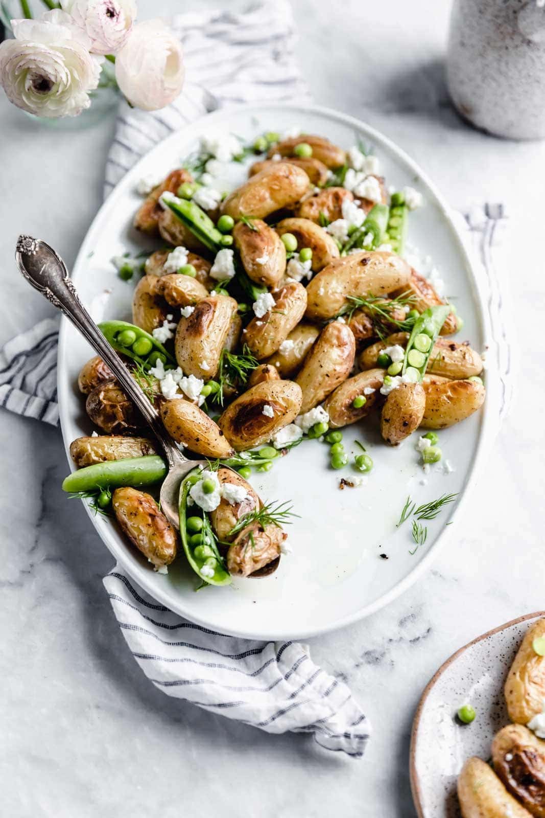 These roasted fingerling potatoes with dill, goat cheese, and peas are our new fav side dish. Full of texture and flavor, you'll love these spring potatoes.