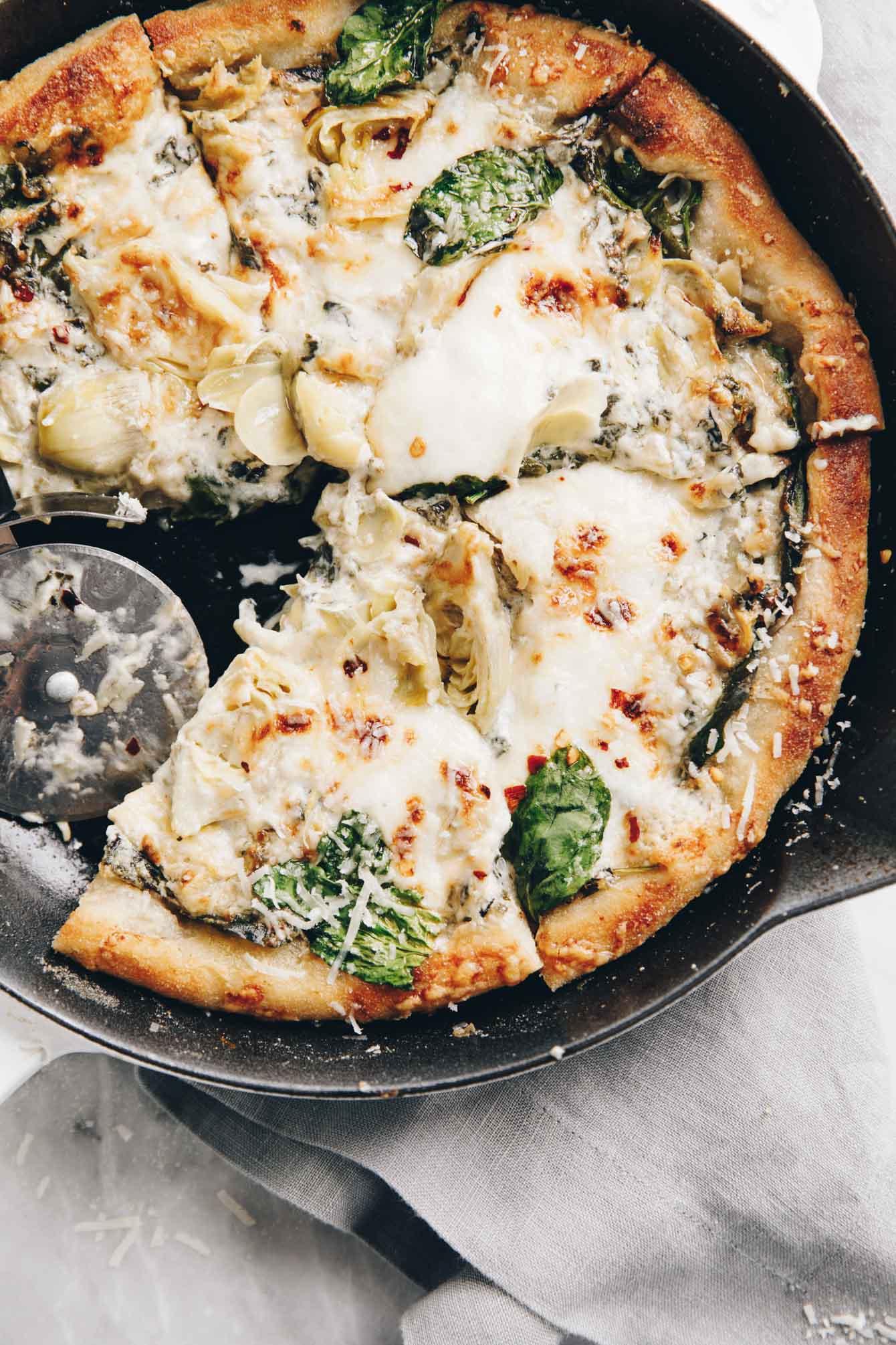 Easy cheesy spinach artichoke pizza so delicious, you'll eat the whole pie yourself