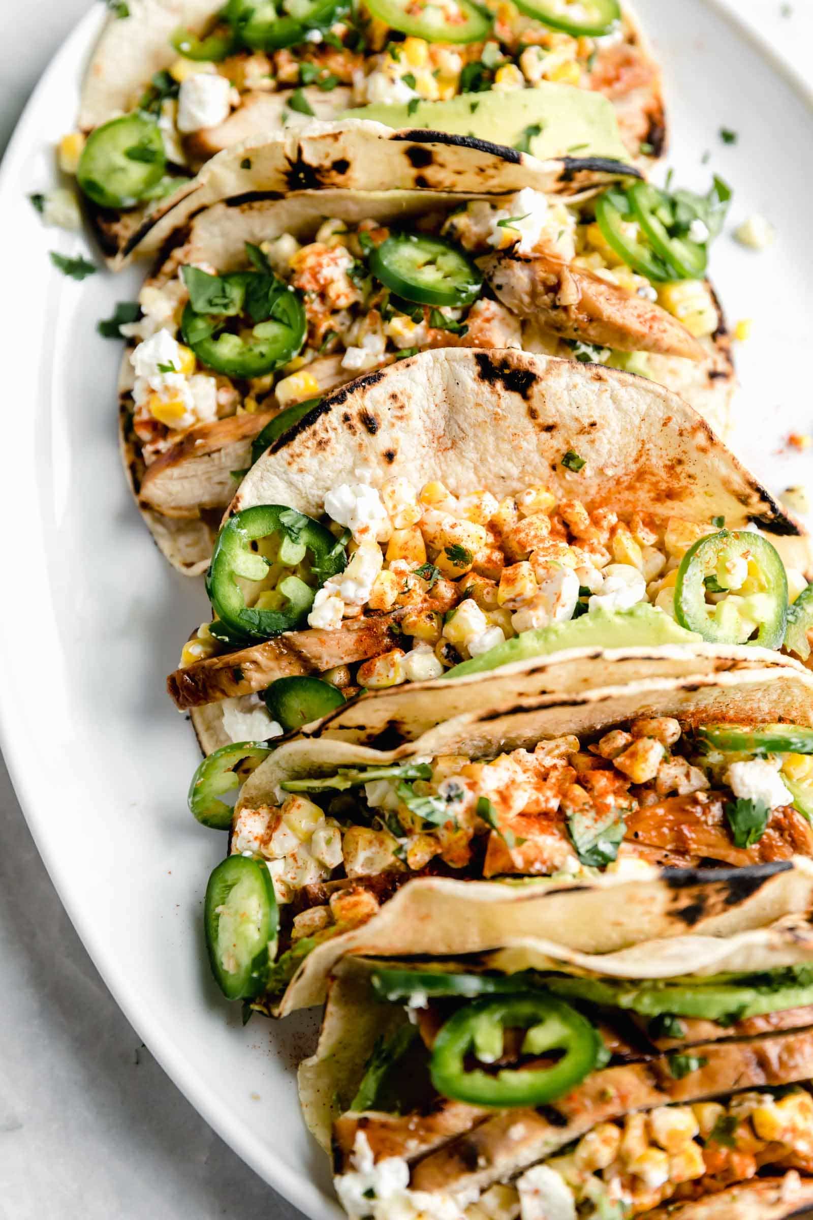 Kicking off Summer Taco Tuesdays with BBQ Chicken Mexican Street Corn tacos loaded with crema, cotija cheese, avocado, and fresh corn. Sign me up!