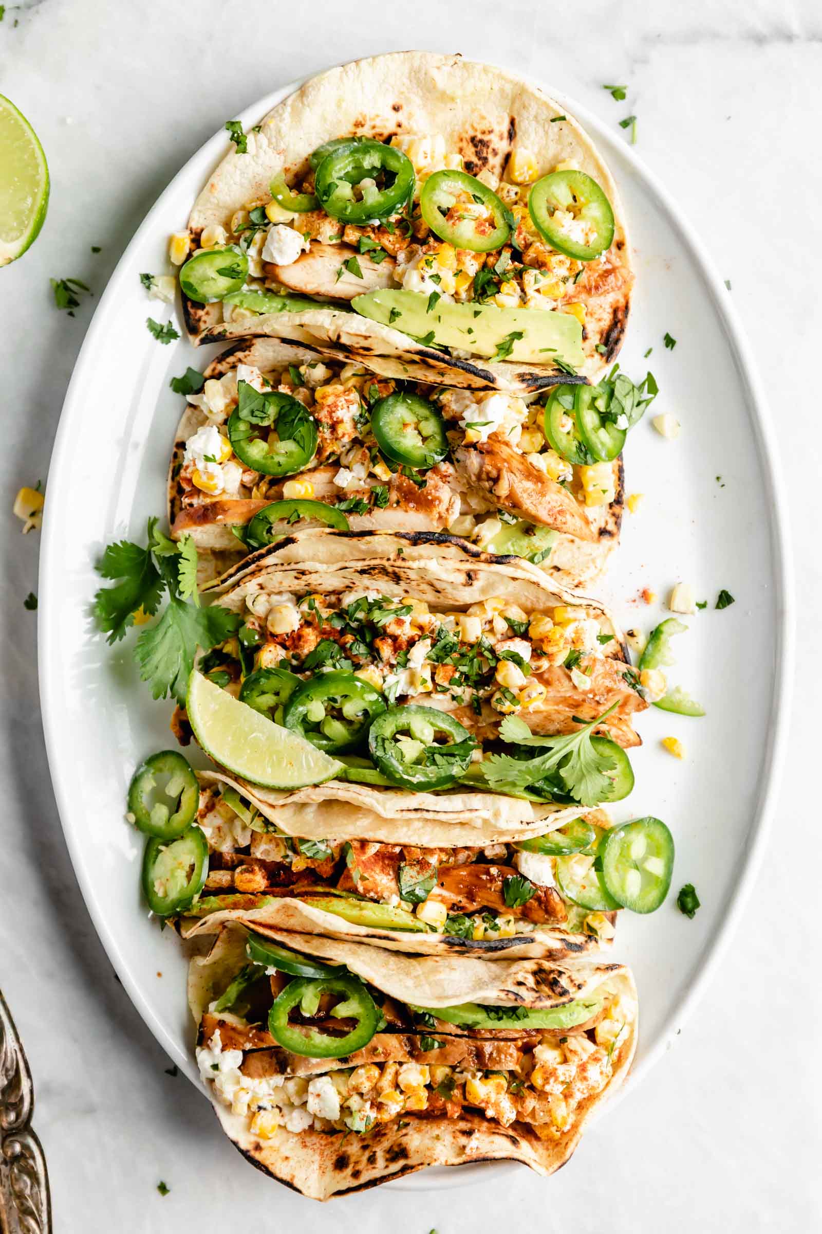 Kicking off Summer Taco Tuesdays with BBQ Chicken Mexican Street Corn tacos loaded with crema, cotija cheese, avocado, and fresh corn. Sign me up!