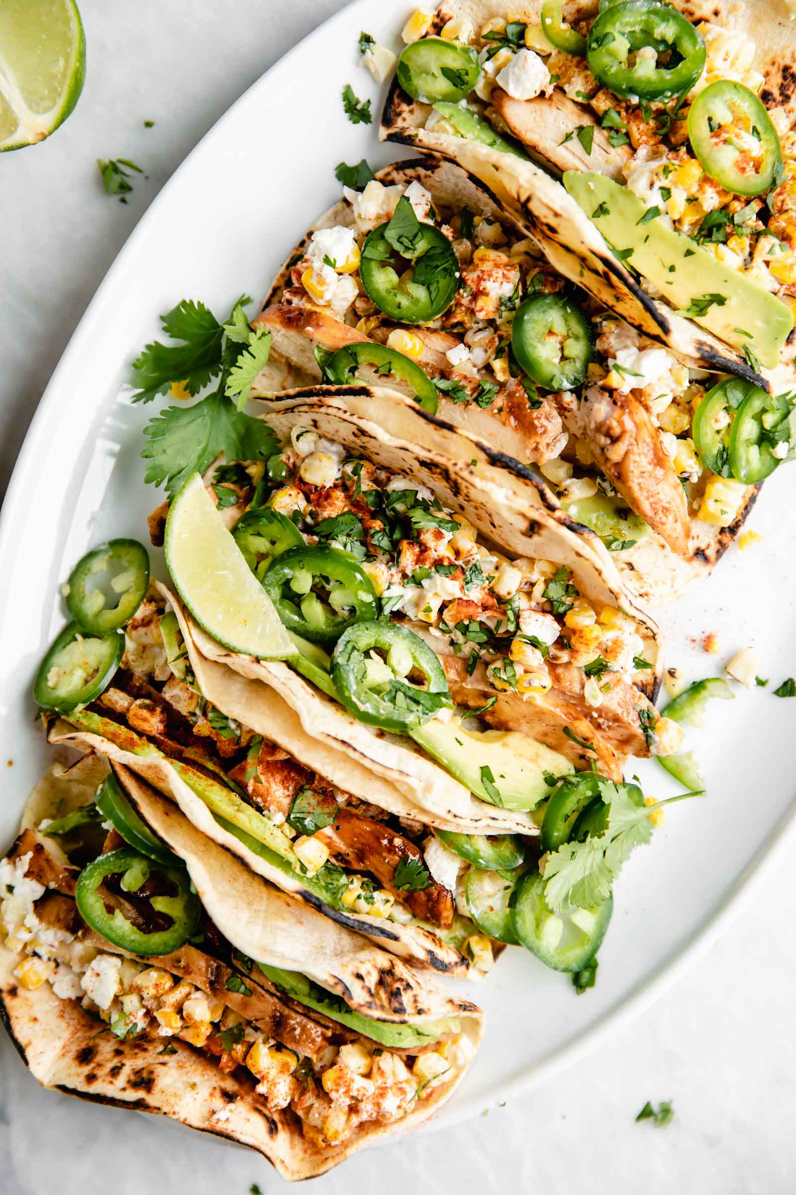 Kicking off Summer Taco Tuesdays with BBQ Chicken Mexican Street Corn tacos loaded with crema, cotija cheese, avocado, and fresh corn. Sign me up!