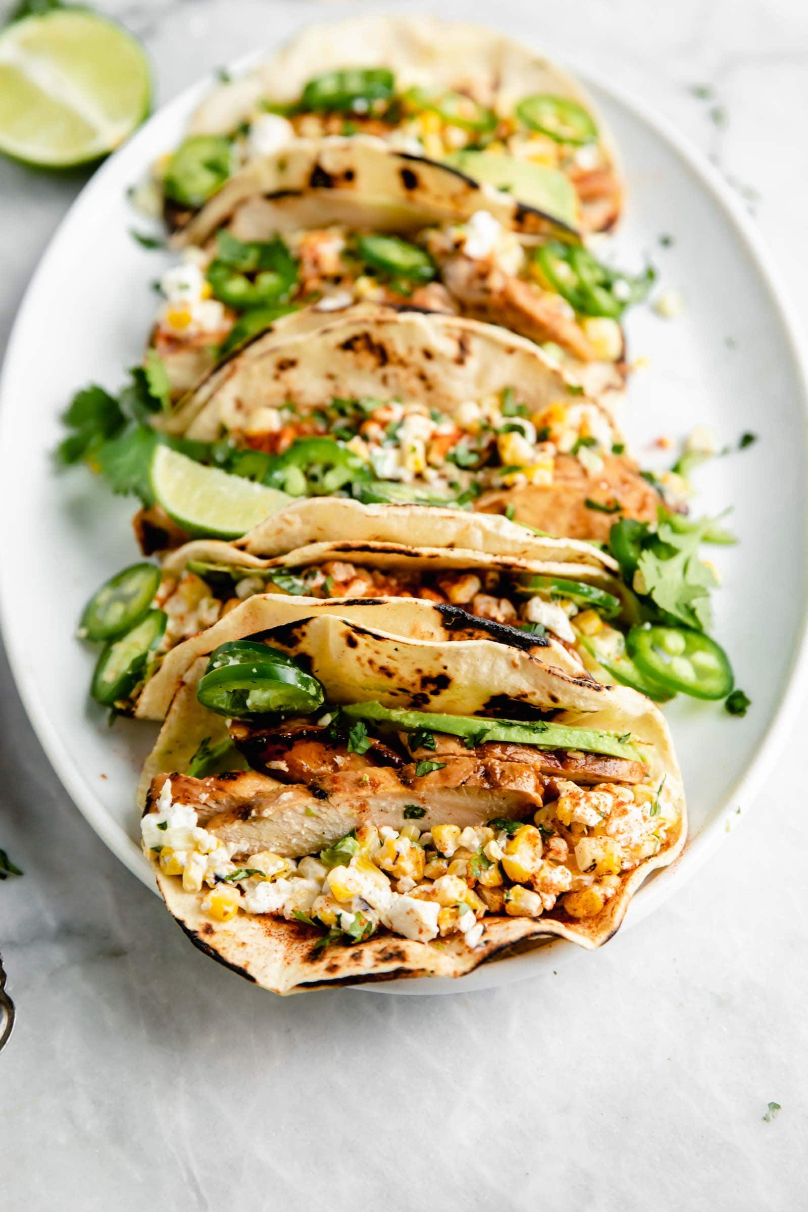 loaded barbecue chicken street corn tacos on a plate