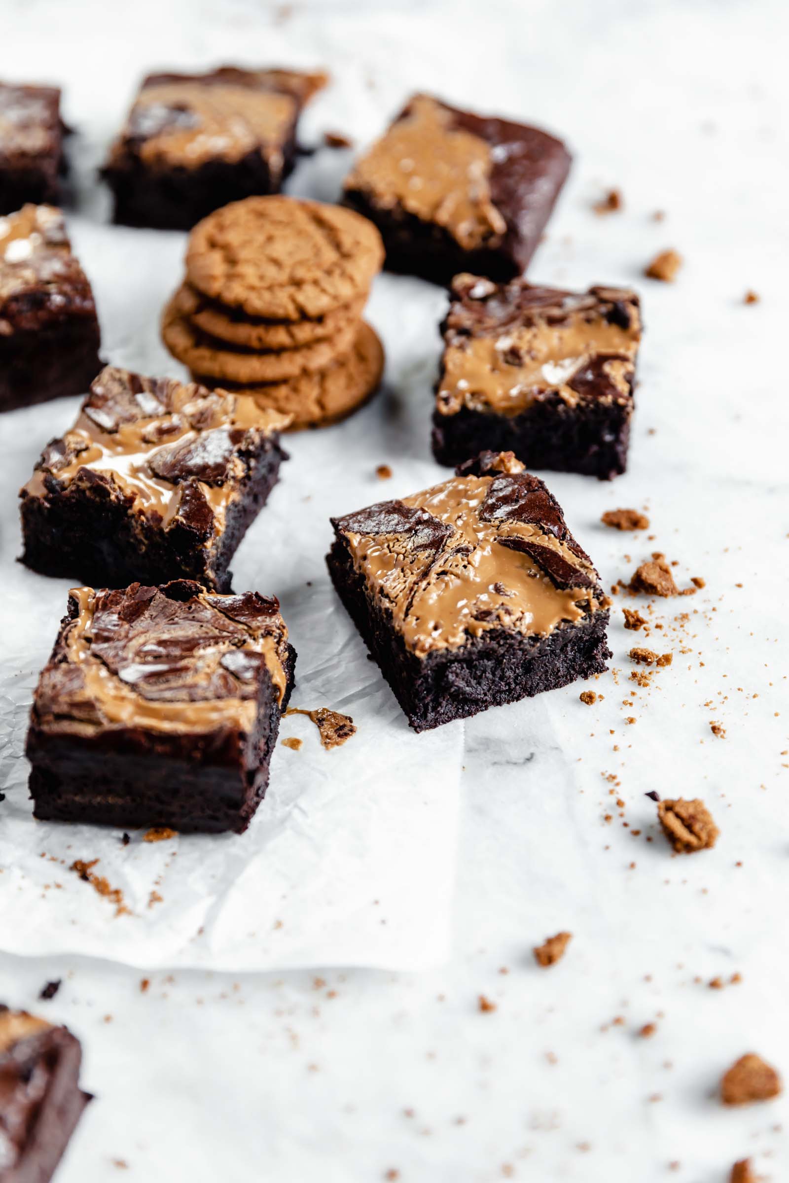 cookie butter brownies with a stack of cookies and cookie crumbs