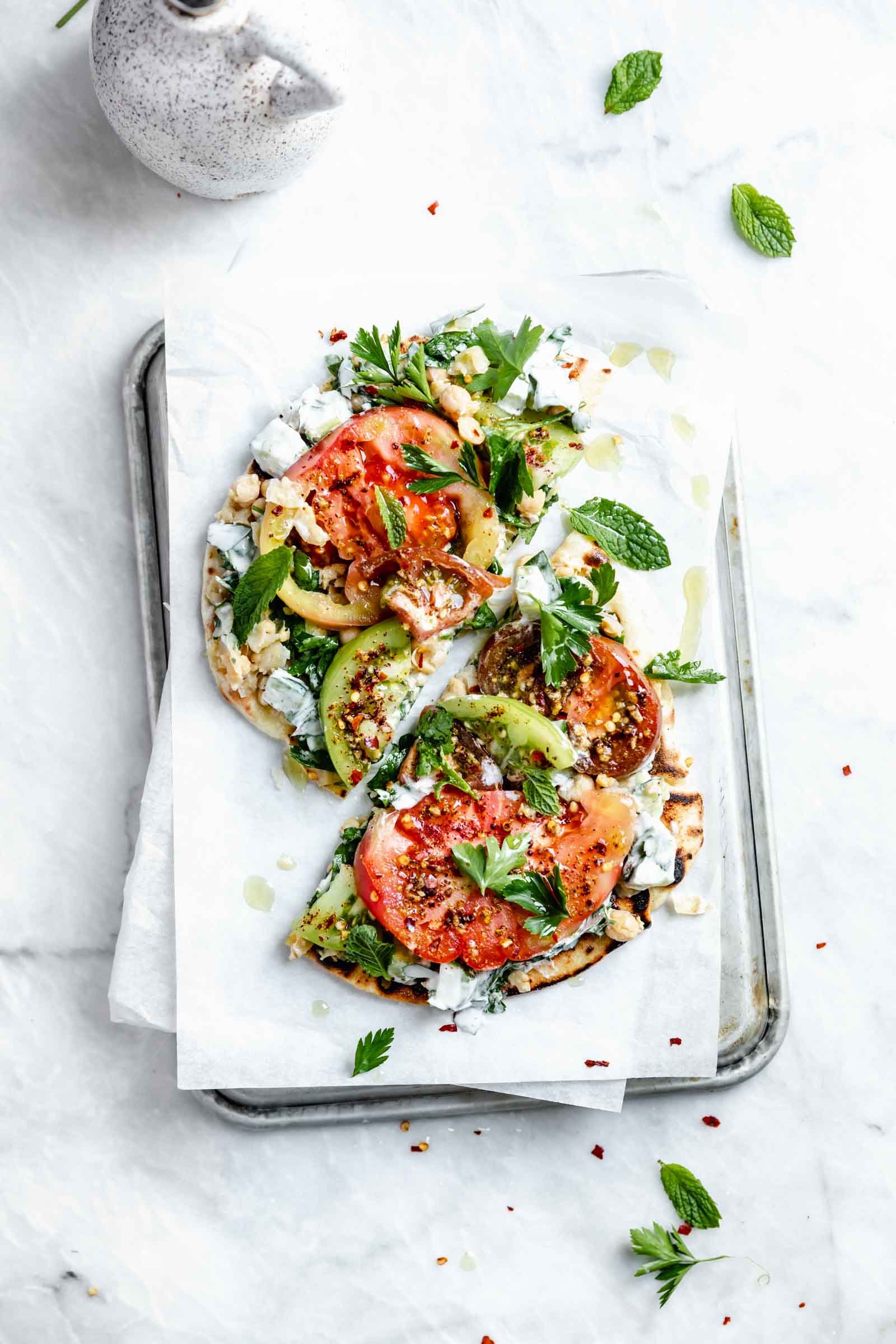 falafel-spice tomato flatbread cut in half on board