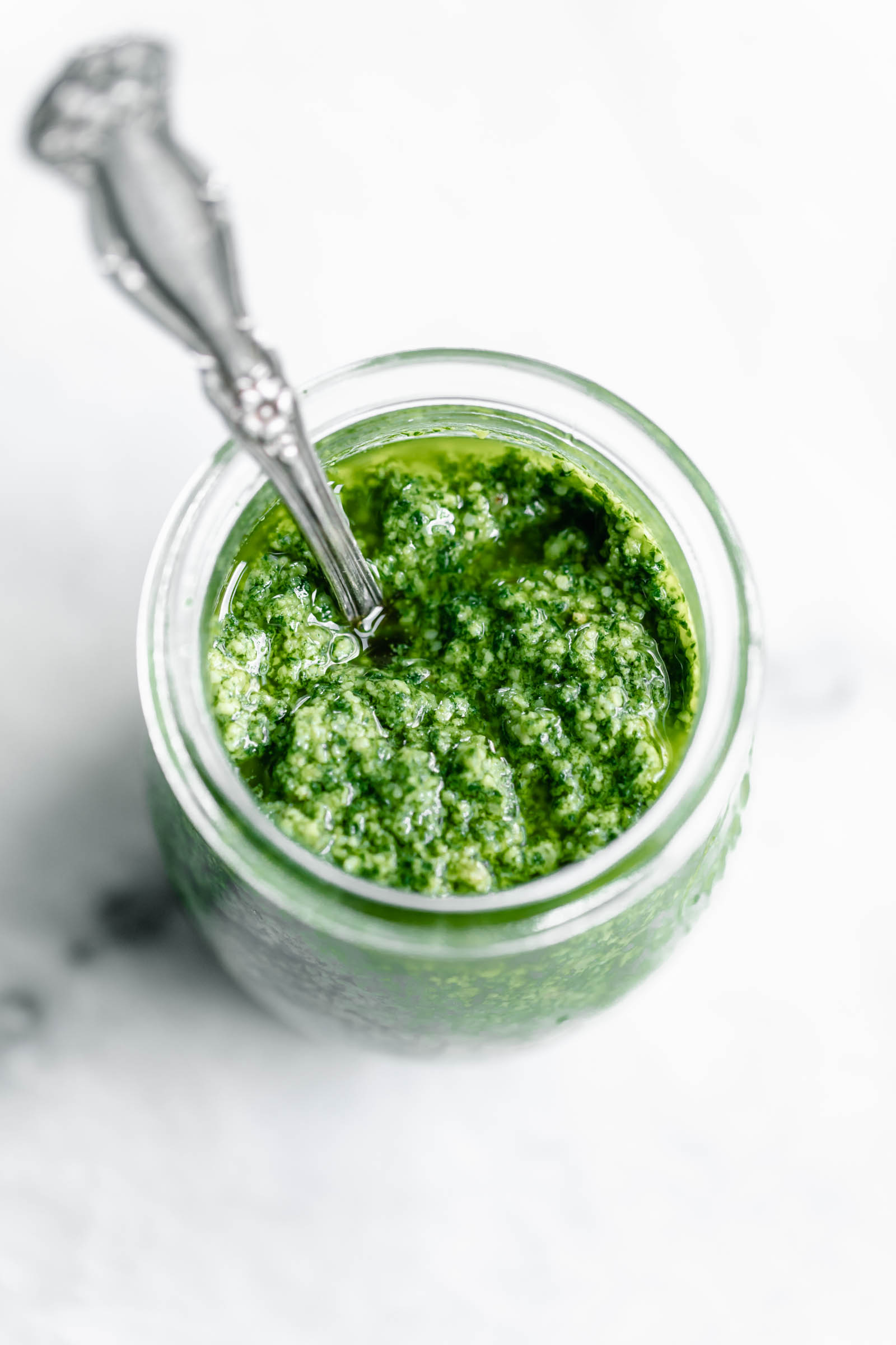 fresh pesto in a jar with a spoon