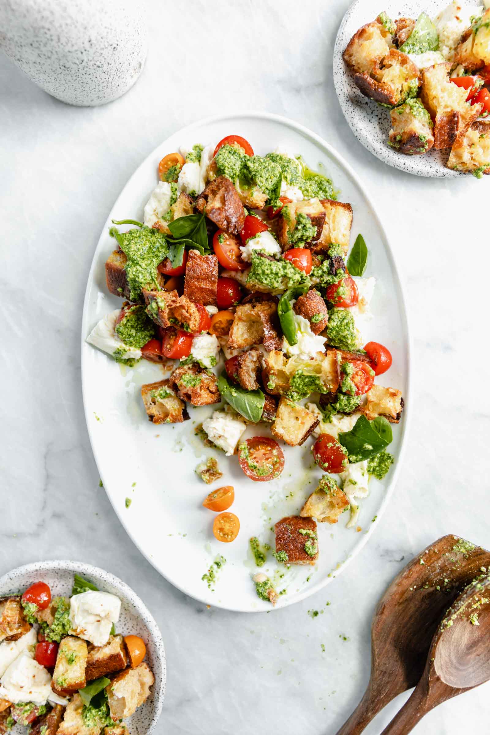 serving dish of panzanella salad with two smaller servings