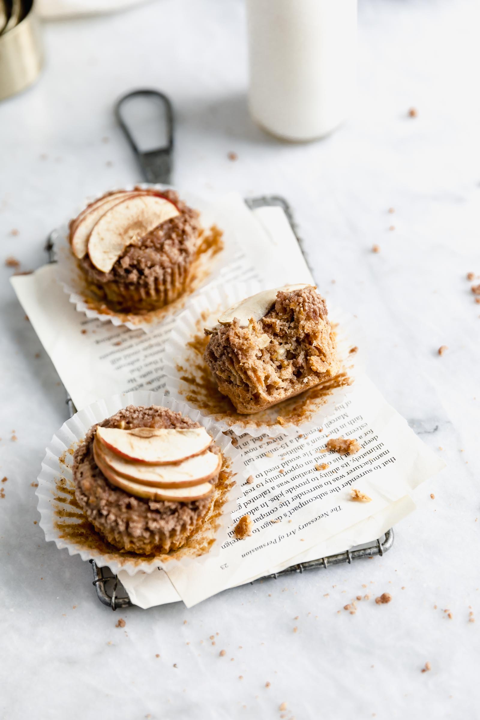 three apple muffins with shredded carrots and coconut with a bite taken out