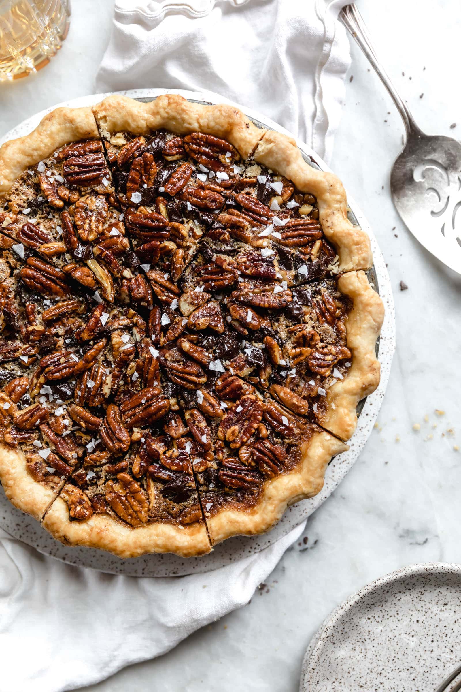 overhead shot of bourbon chocolate pecan pie with pie cutter