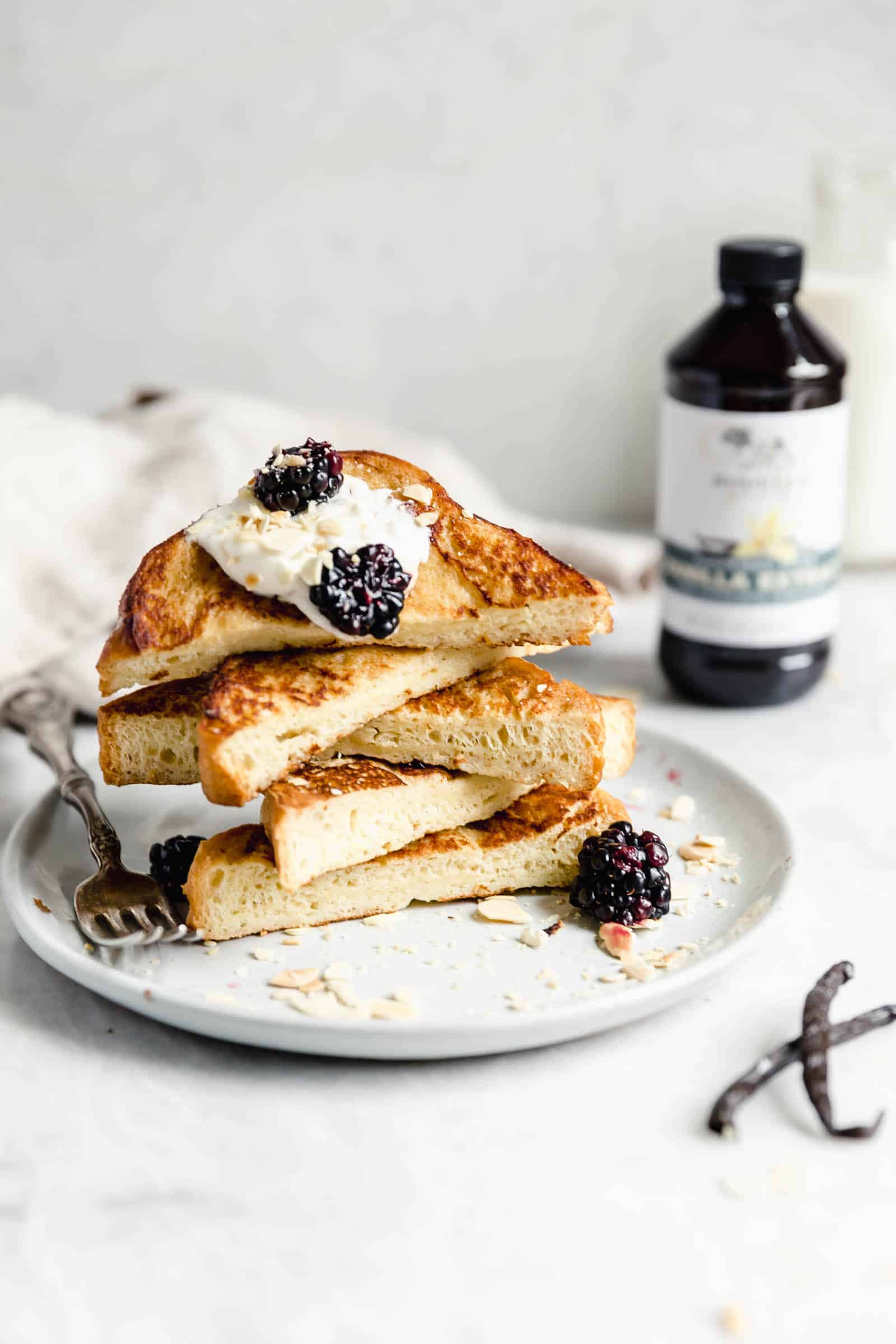 french toast cut into triangles topped with whipped cream and berries