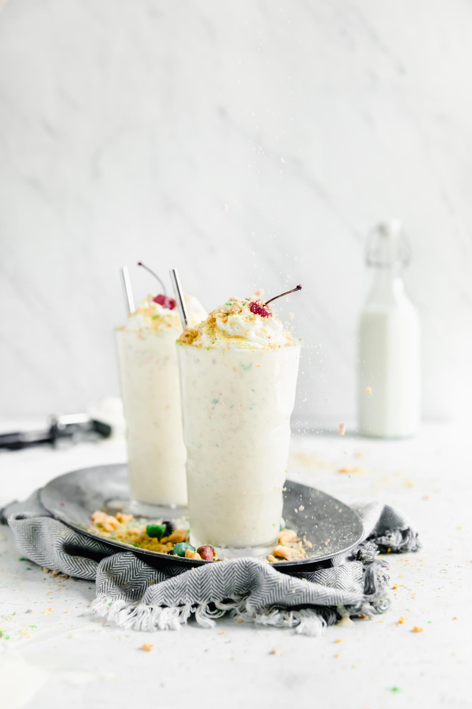 two milk shakes with captain crunch on a plate