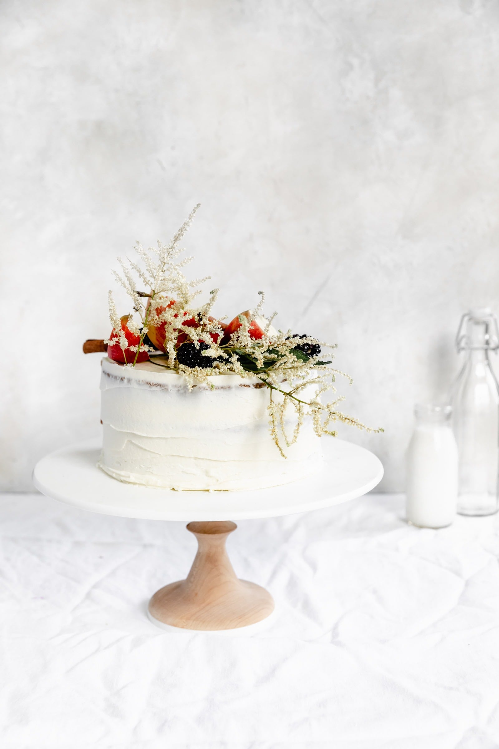 caramel apple cake witih fall flowers on a cake stand 