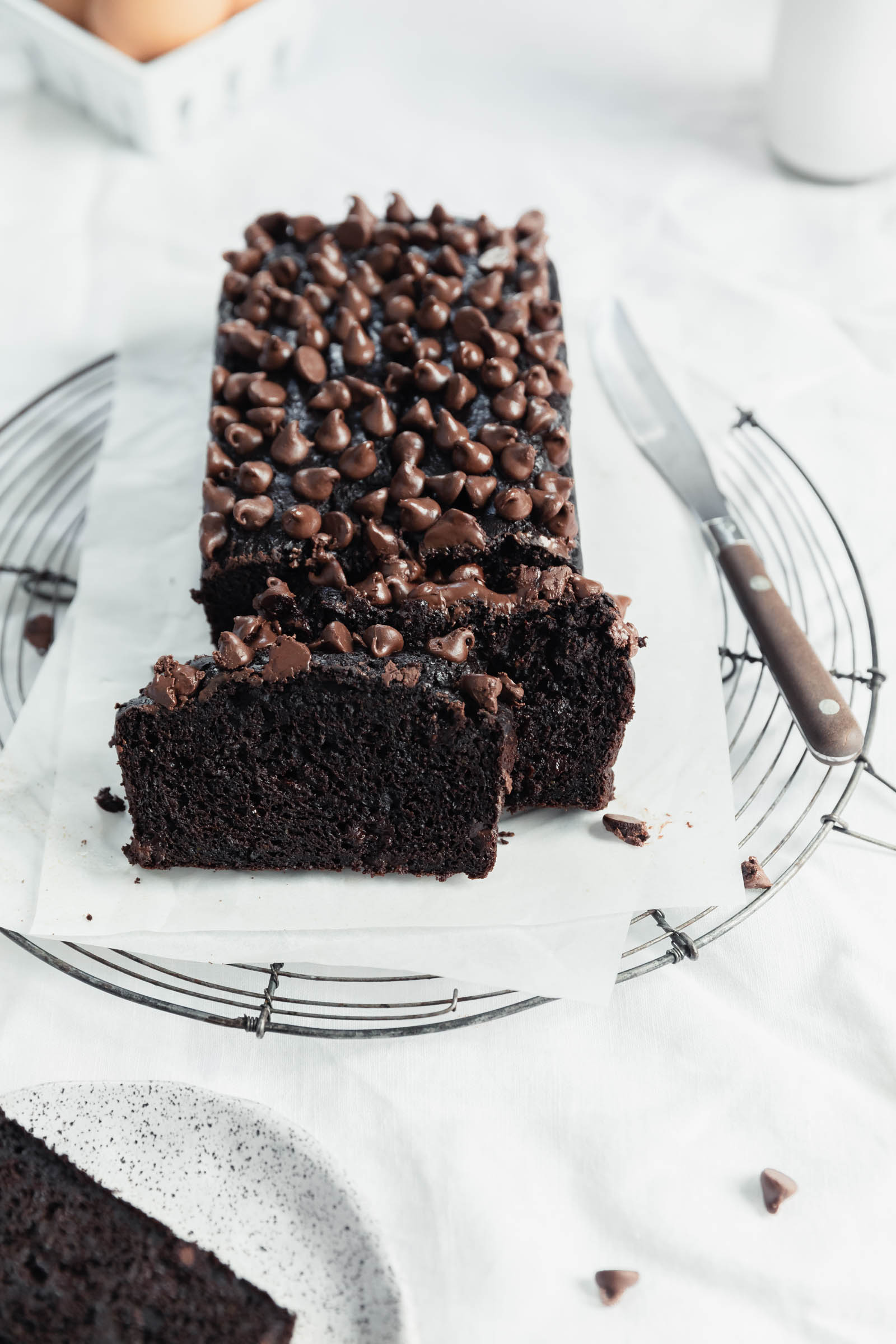 double chocolate zucchini bread with a slice and chocolate crumbs