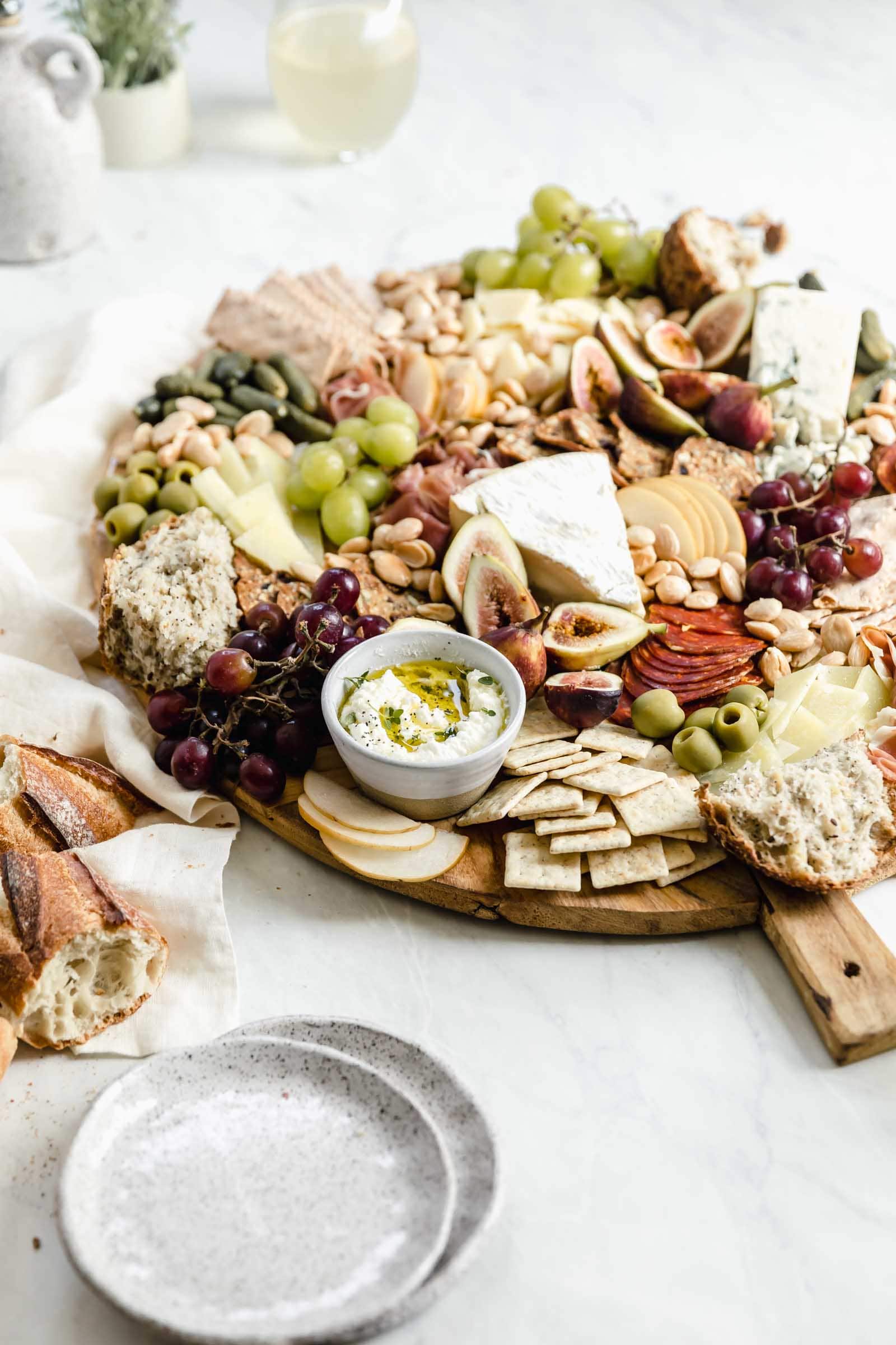 loaded cheeseboard on wooden board with wine