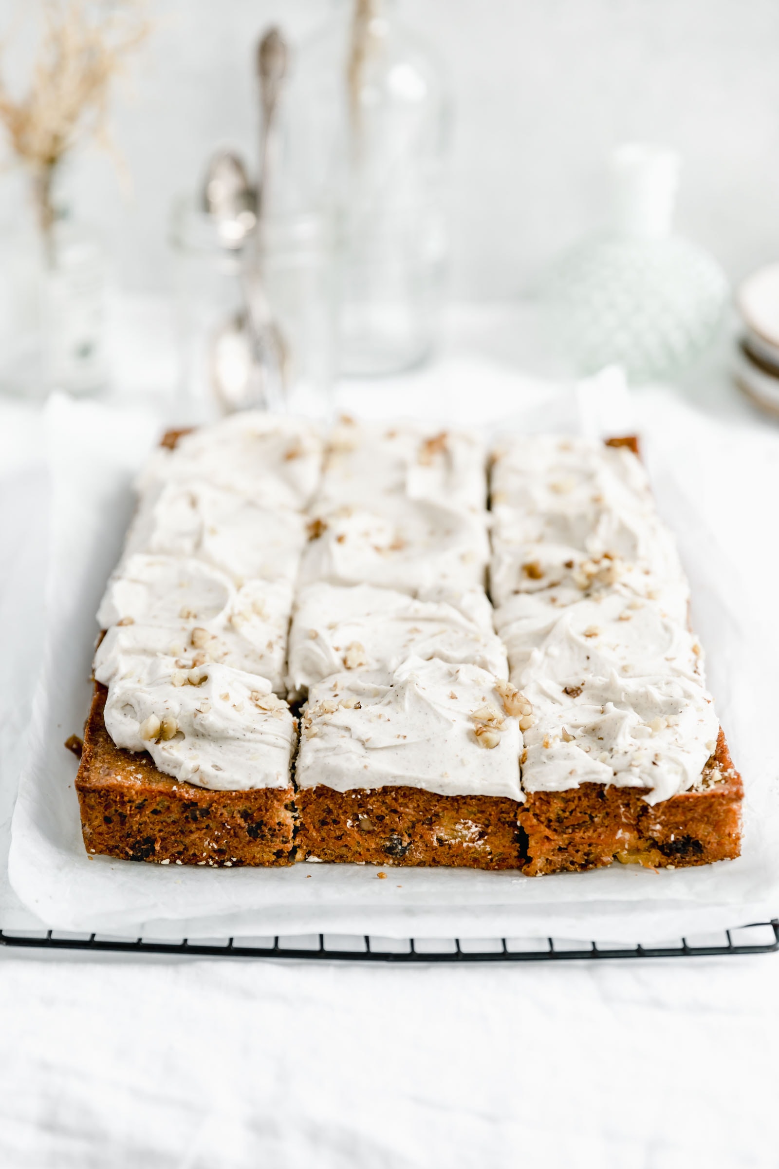 carrot sheet cake with a thick layer of cream cheese frosting cut into 12 pieces
