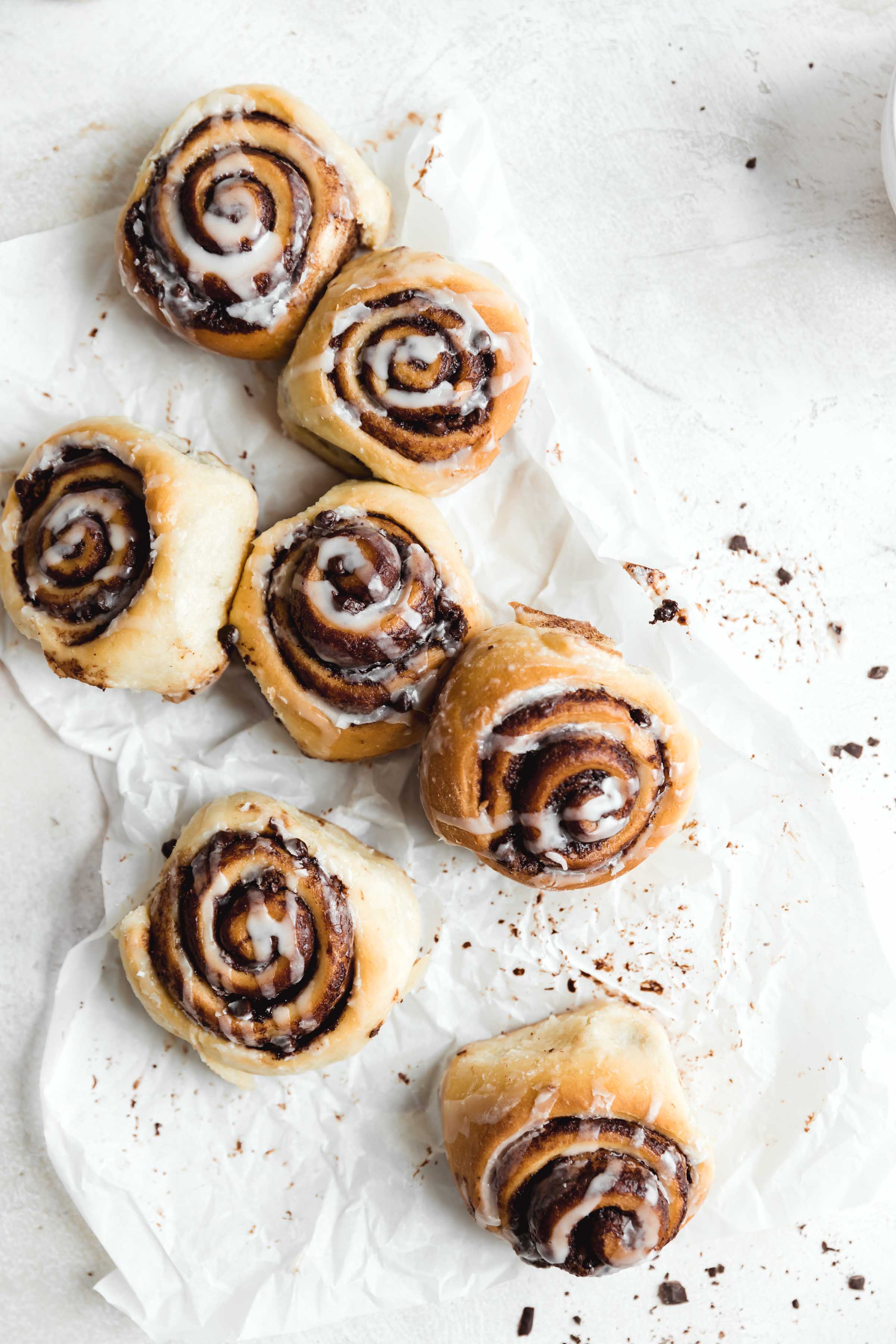 overhead shot of chocolate cinnamon rolls drizzled with cream cheese icing