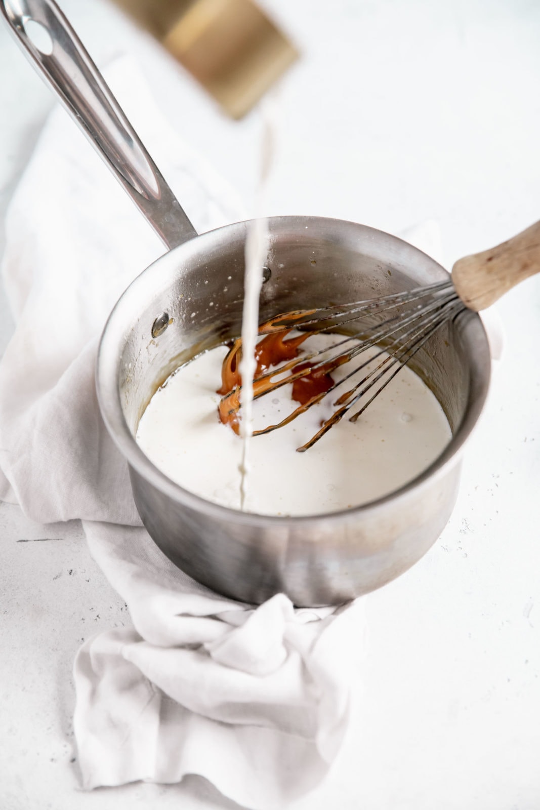 cream poured into saucepan with caramel