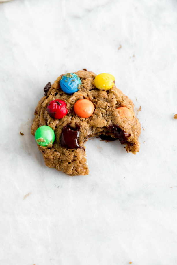 Bite shot of healthyish mosnter cookies studded with m and ms and dark chocolate chips