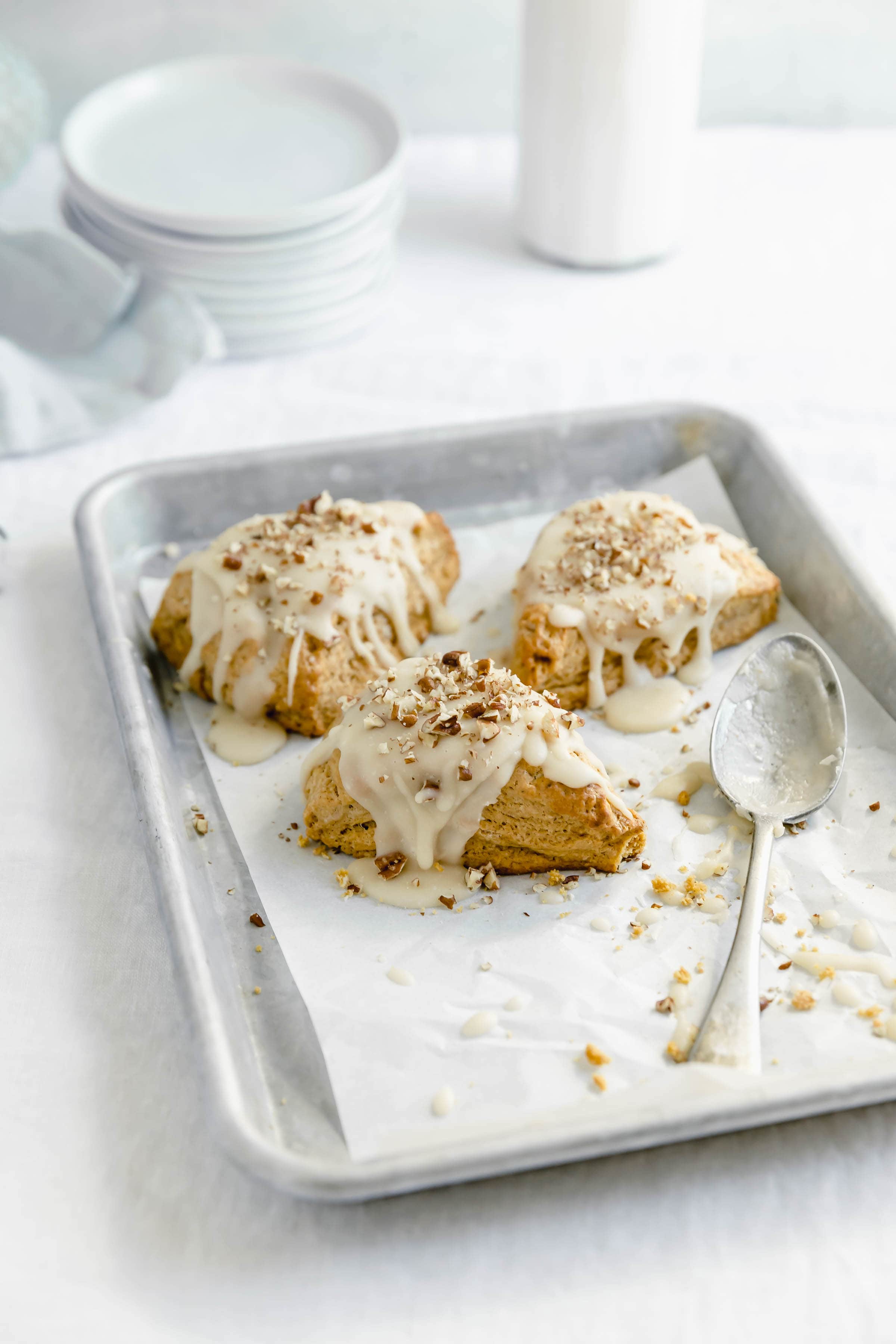 glazed pumpkin scones on a cookie sheet