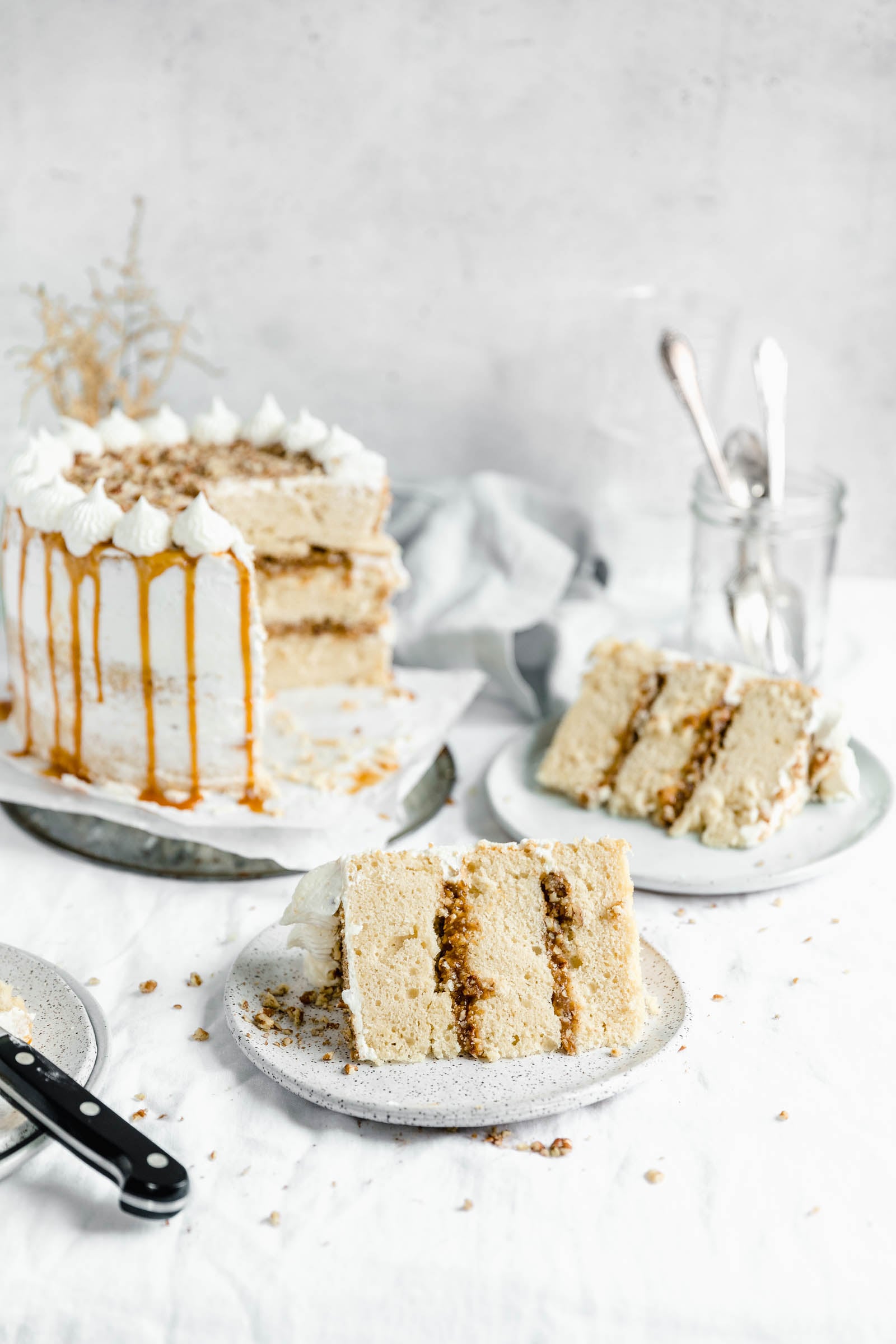 This decadent praline layer cake is the perfect centerpiece for all your Fall celebrations! Made with a moist and tender vanilla cake sandwiched together with a gooey homemade praline feeling and frosted with fluffy buttercream. Um YES. #bromabakery #pralinelayercake #foodphotography