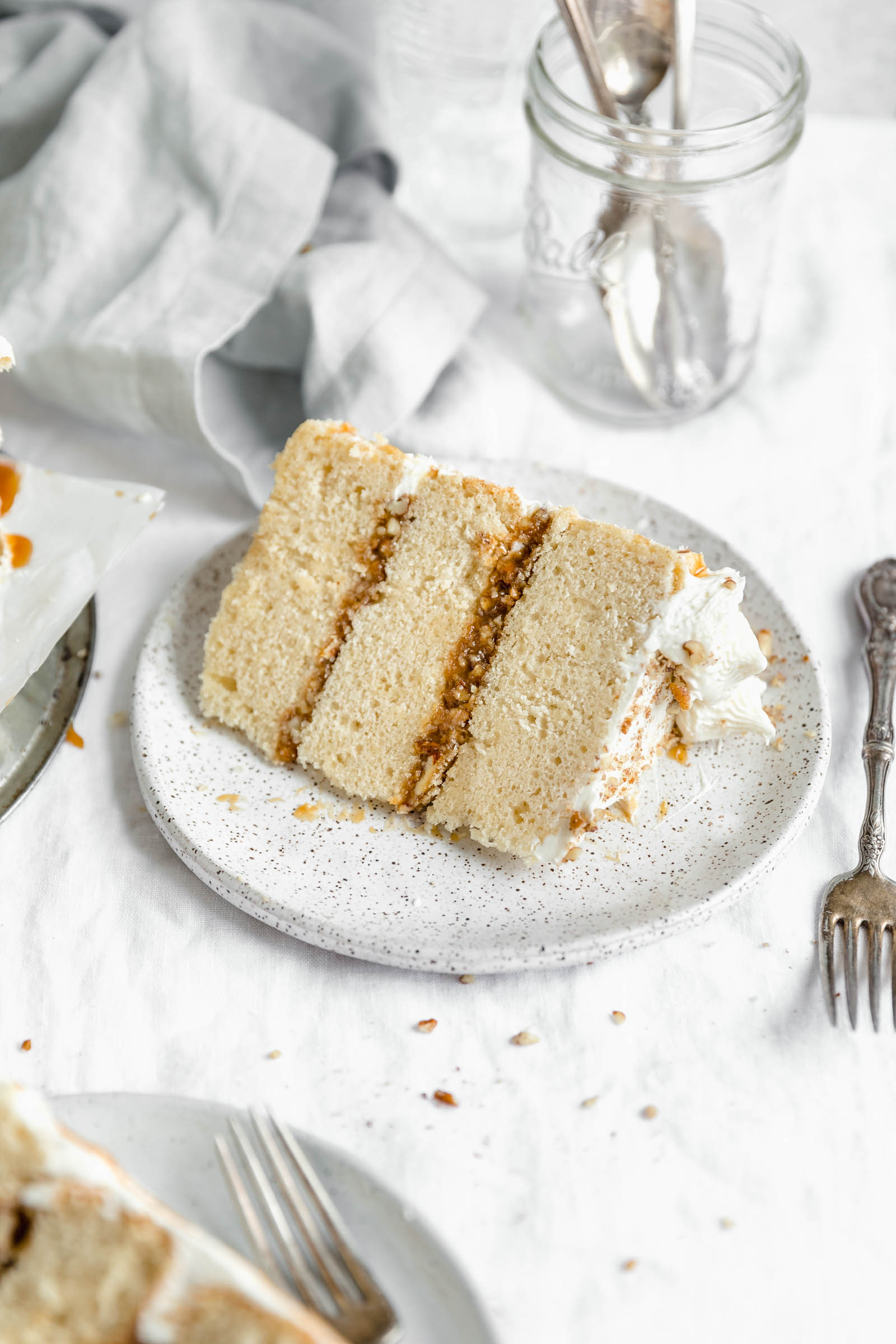 This decadent praline layer cake is the perfect centerpiece for all your Fall celebrations! Made with a moist and tender vanilla cake sandwiched together with a gooey homemade praline feeling and frosted with fluffy buttercream. Um YES. #bromabakery #pralinelayercake #foodphotography