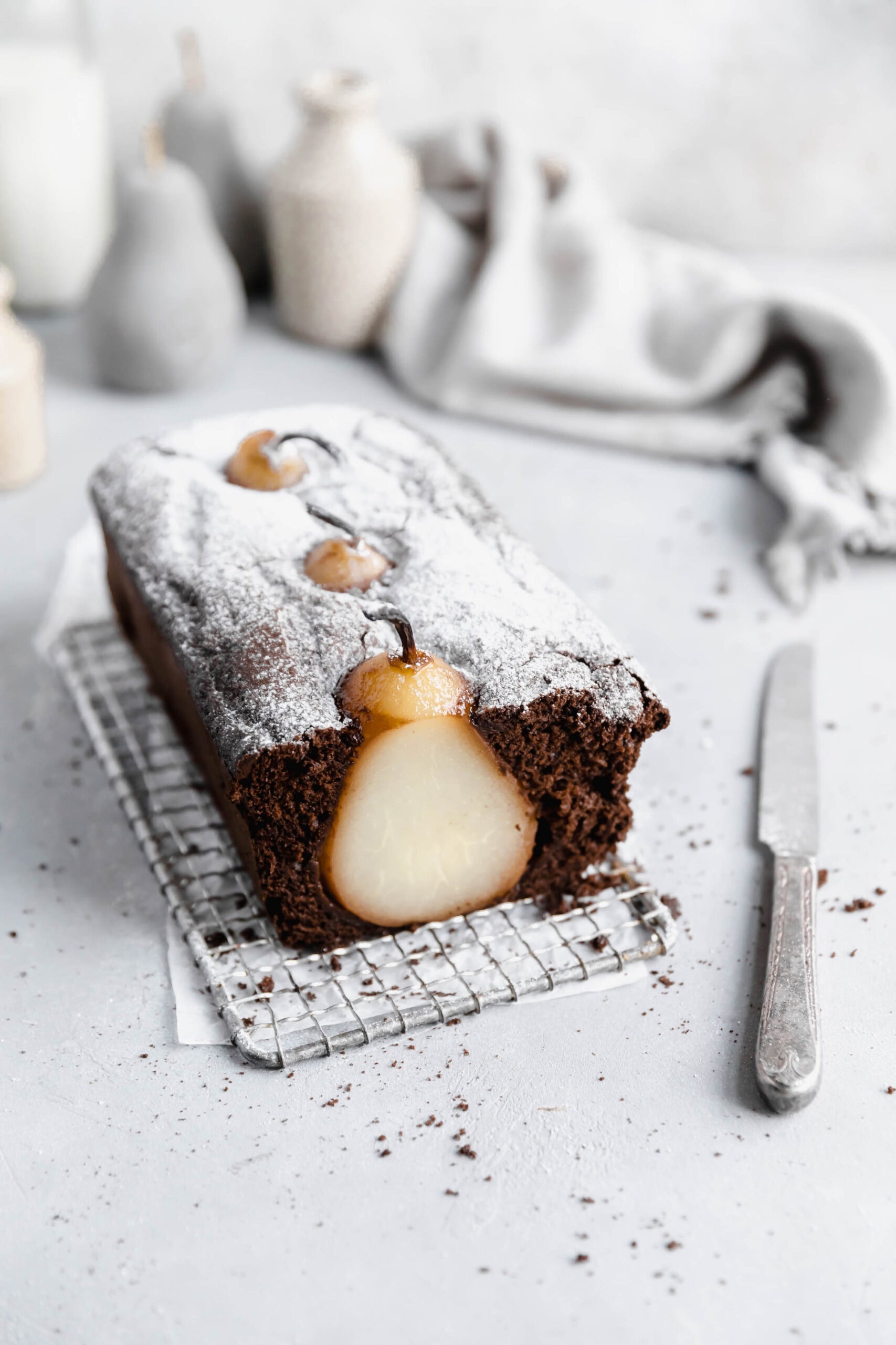 cross section of poached pear gingerbread loaf cake on a cooling rack