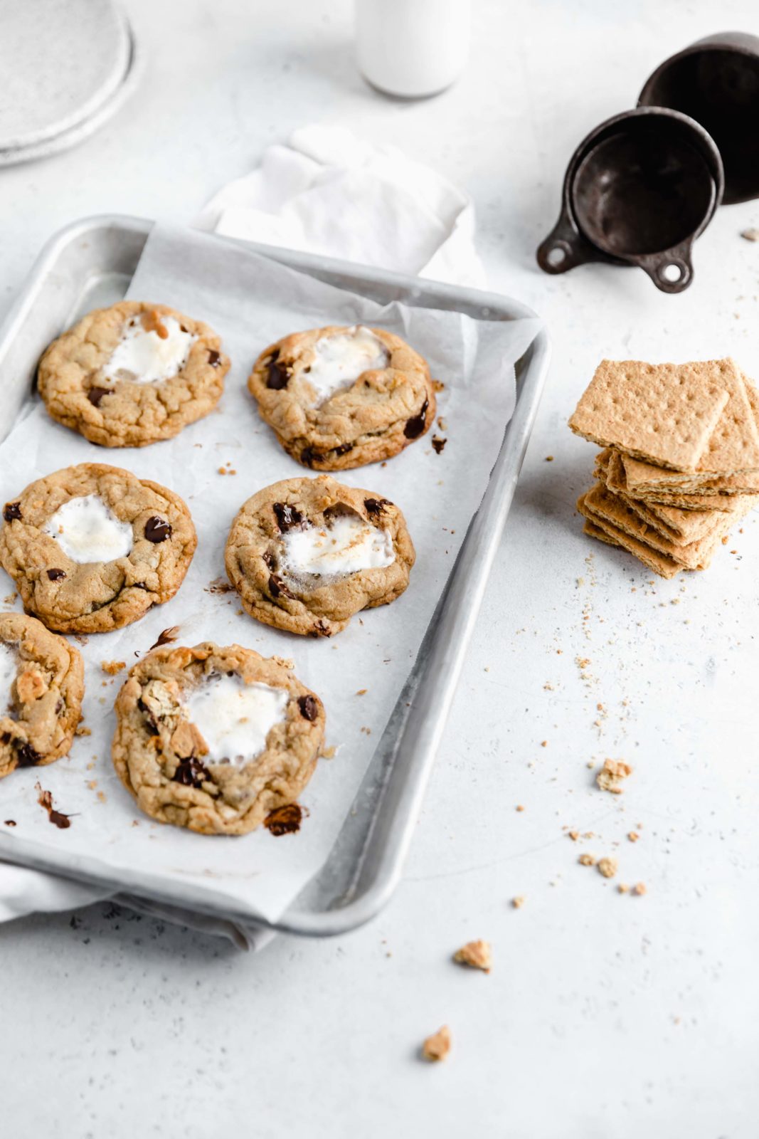 browned butter chocolate chip cookies stuffed with marshmallows and graham crackers on a cookie sheet