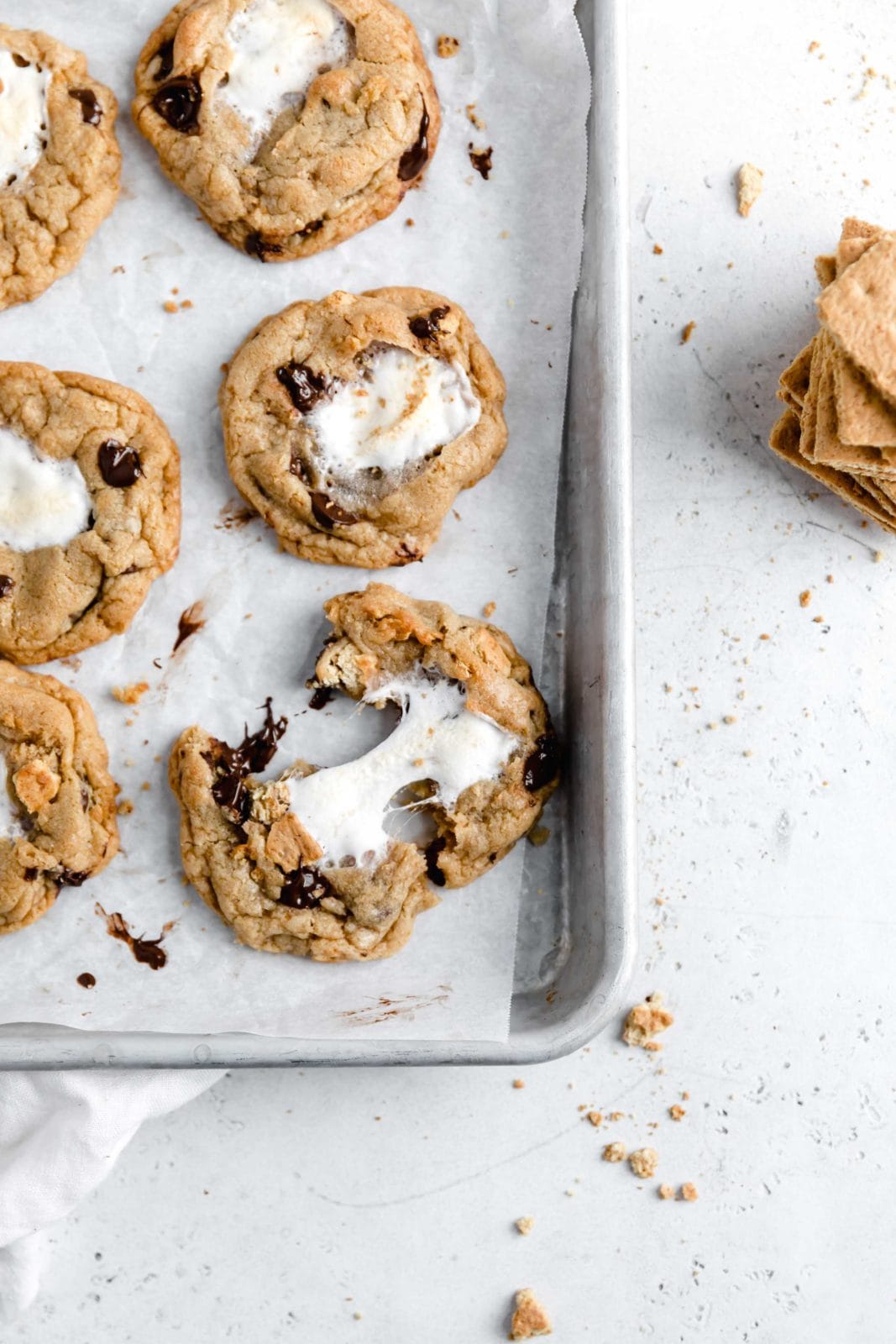 Introducing S’mores Cookies, complete with brown butter dough, chocolate chips, graham cracker crumbs and a gooey marshmallow center. Uh drool!
