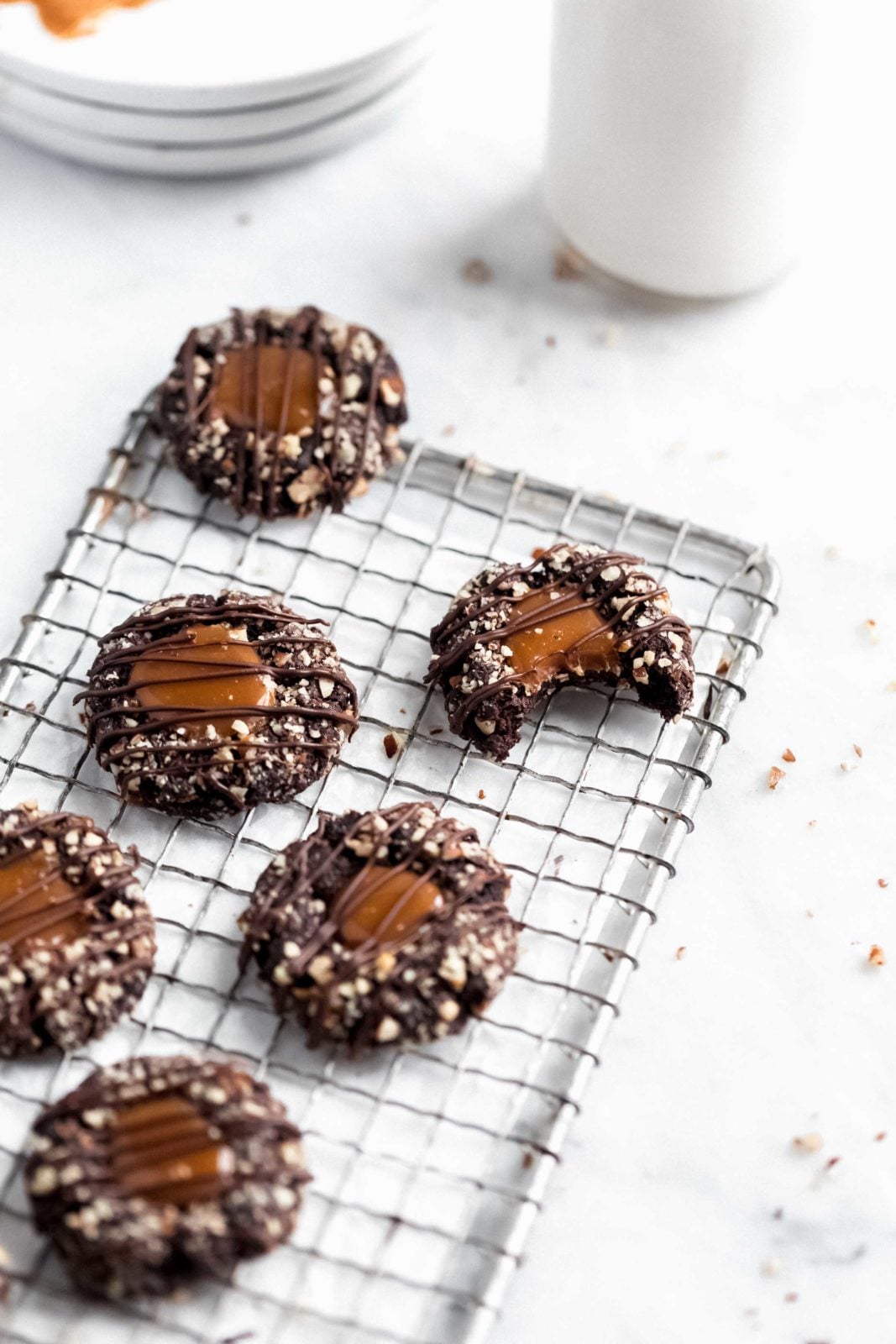 turtle thumbprint cookies on a wire rack with a glass of milk