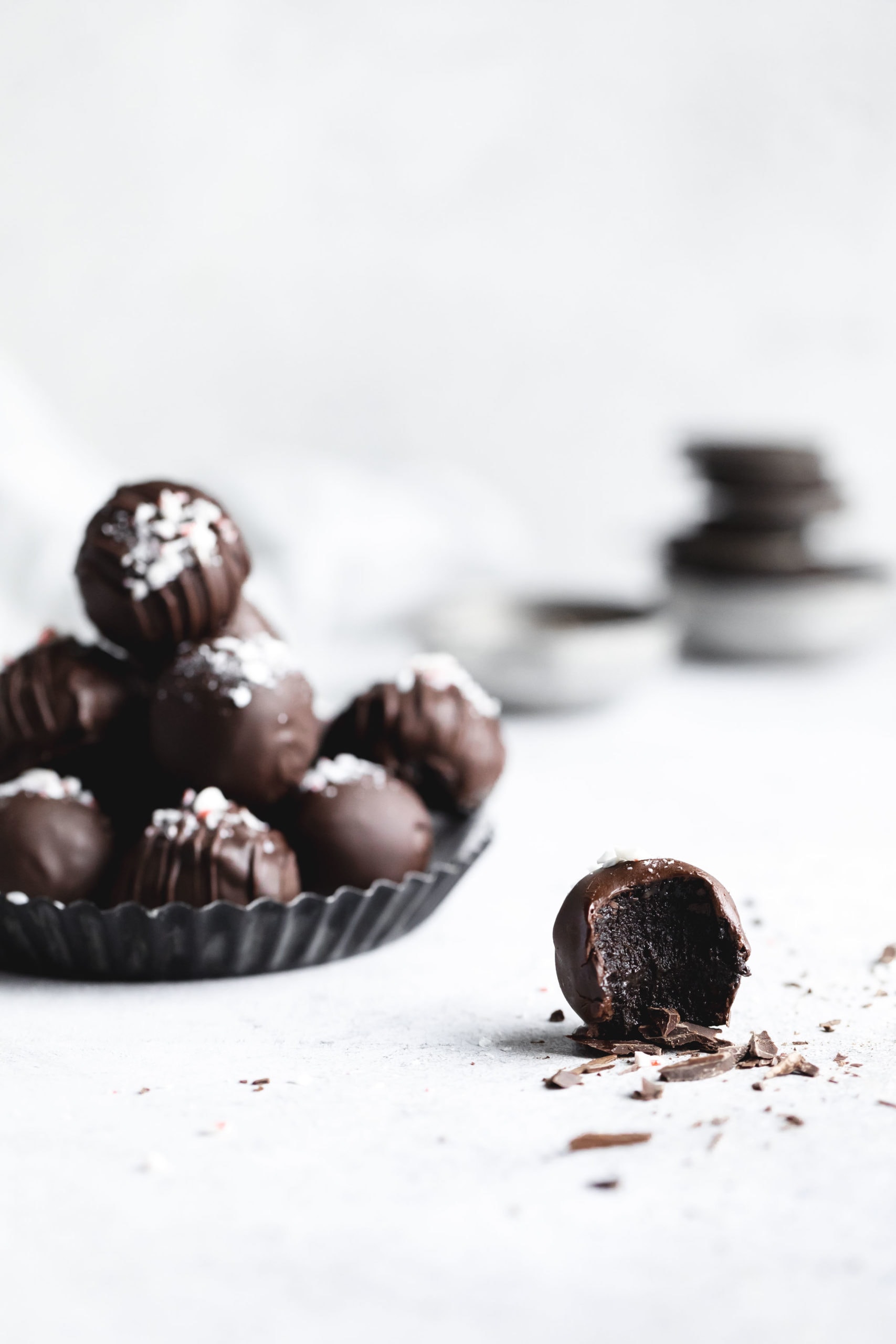straight on shot of peppermint oreo truffles with one oreo truffle with a bite out of it