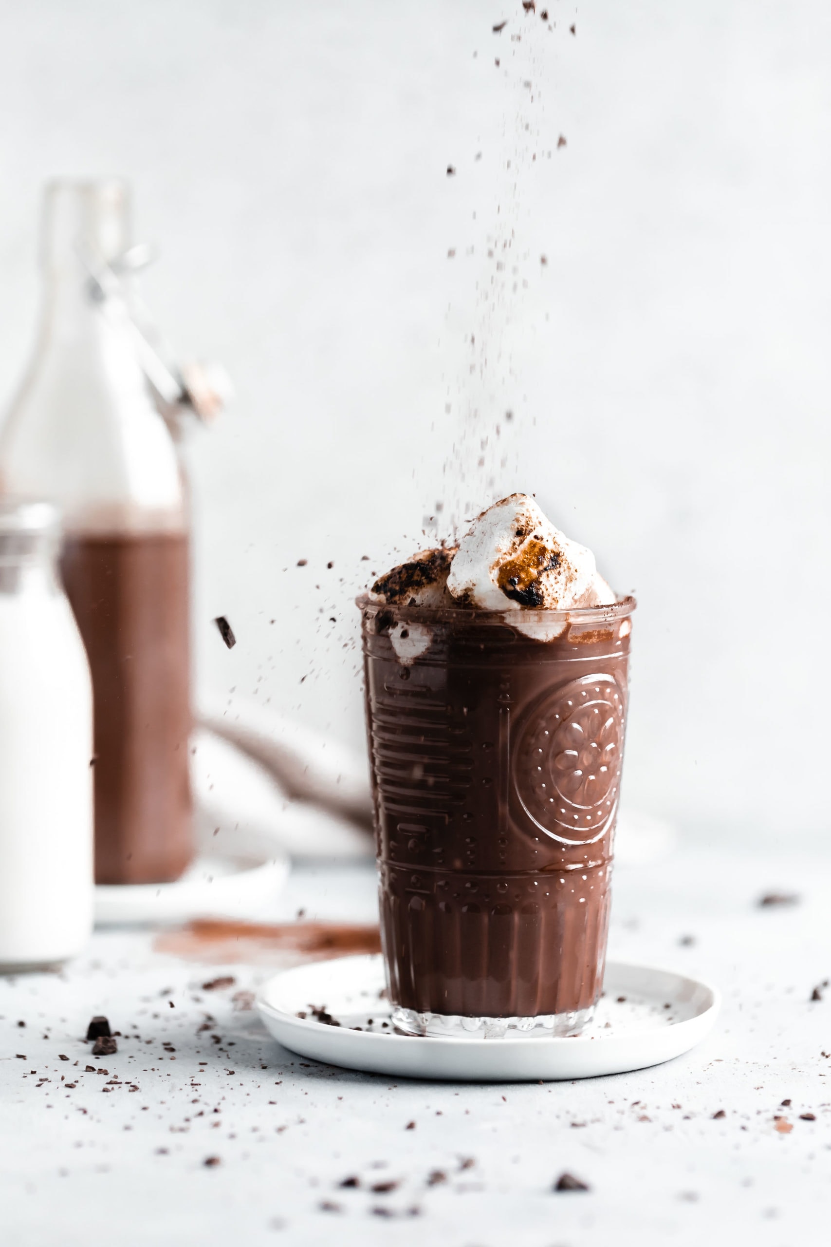 hot chocolate single serving being sprinkled with chocolate