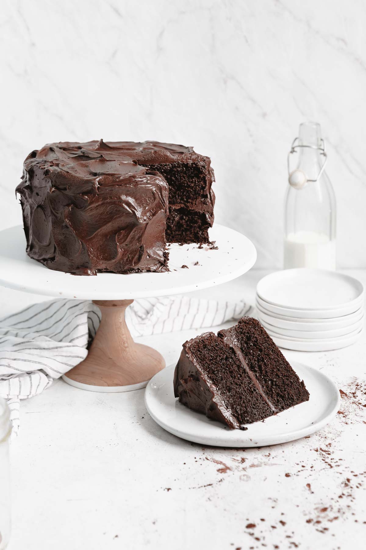 chocolate cake on a cake stand with a slice taken out