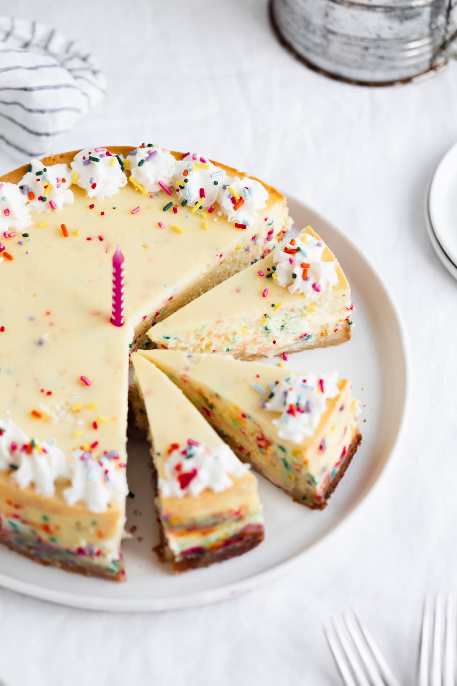 easy birthday cake cheesecake cut into pieces