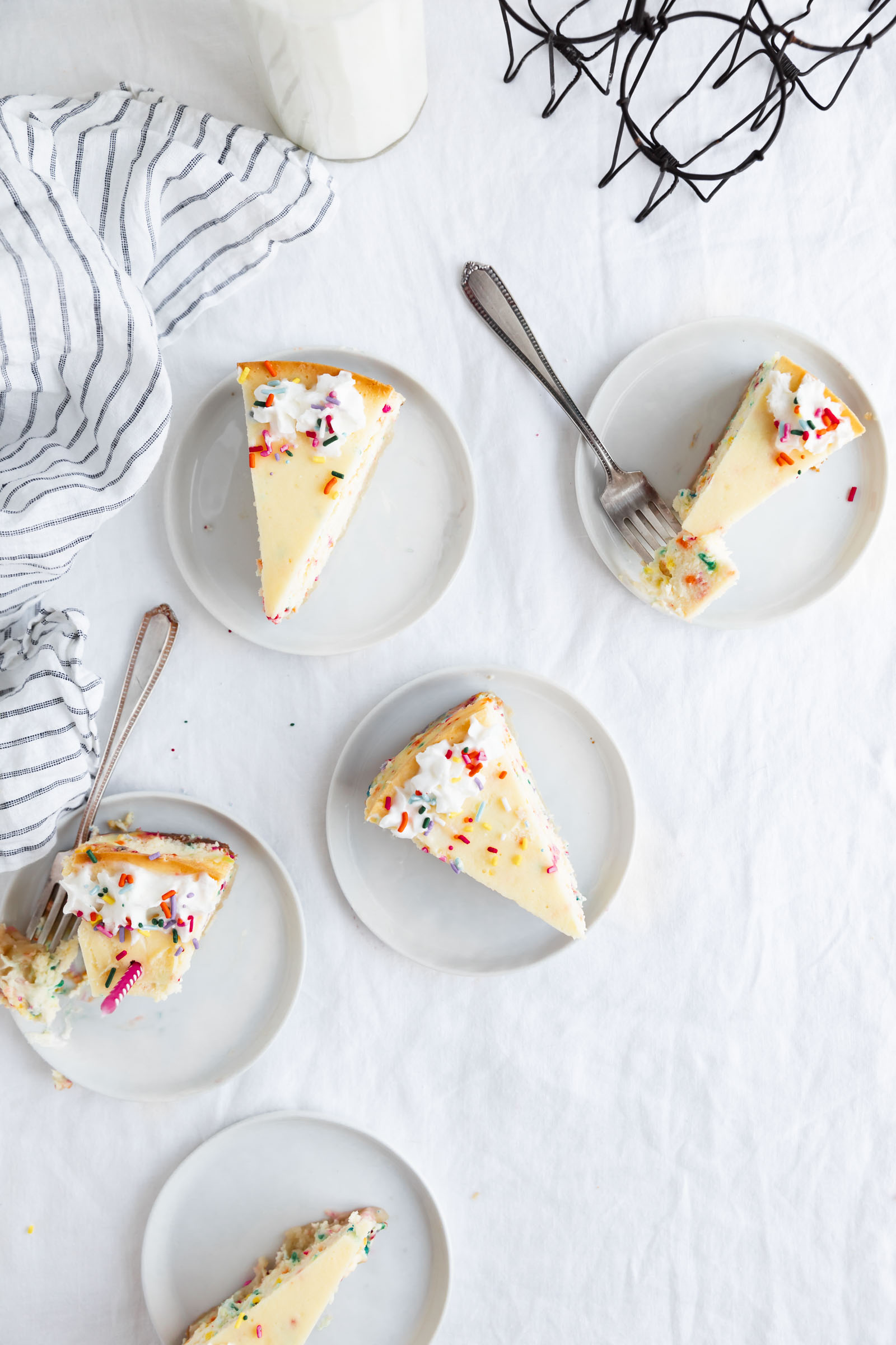 plates of birthday cheesecake with forks