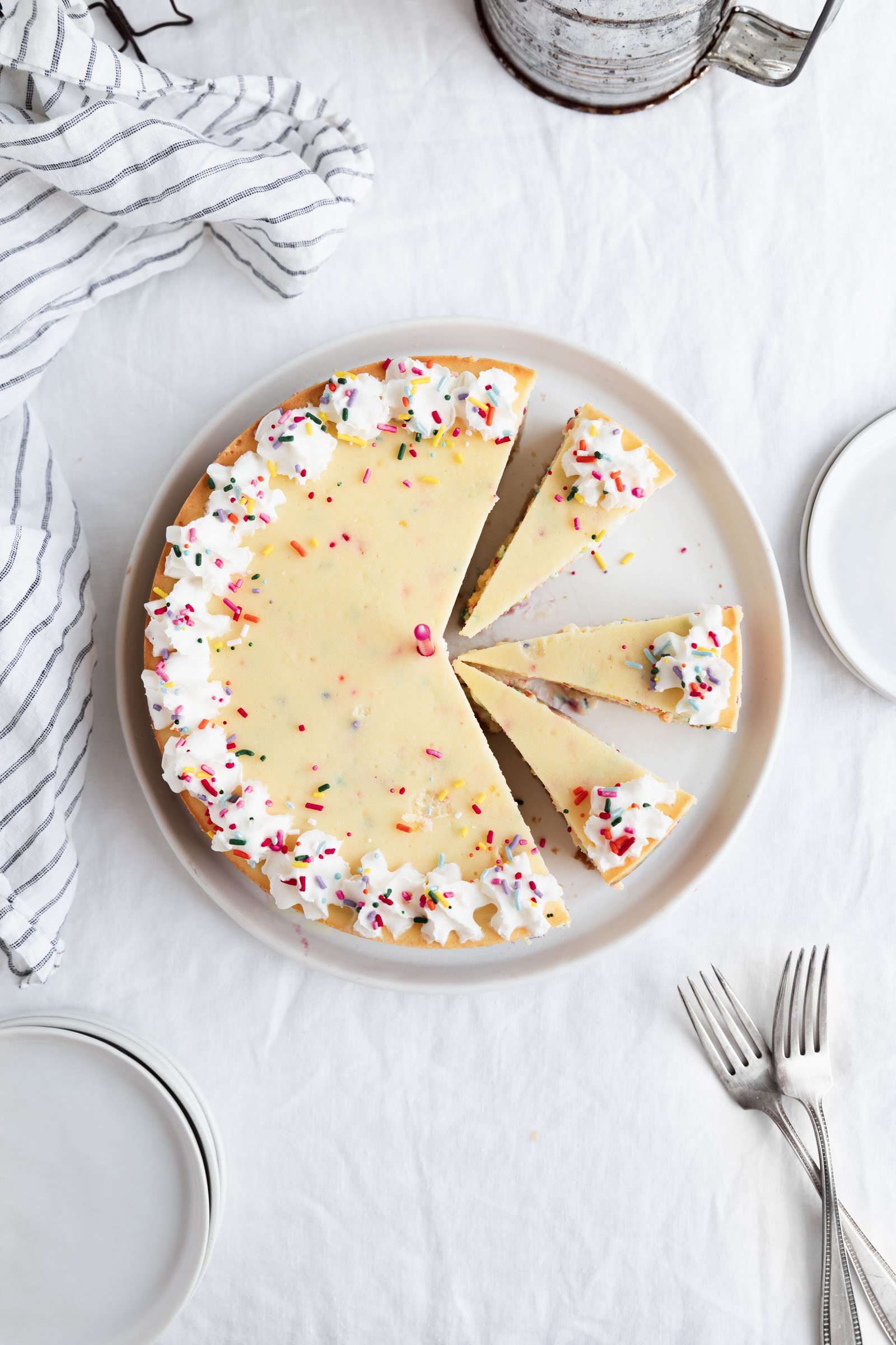 full birthday cheesecake with sprinkles and whipped cream