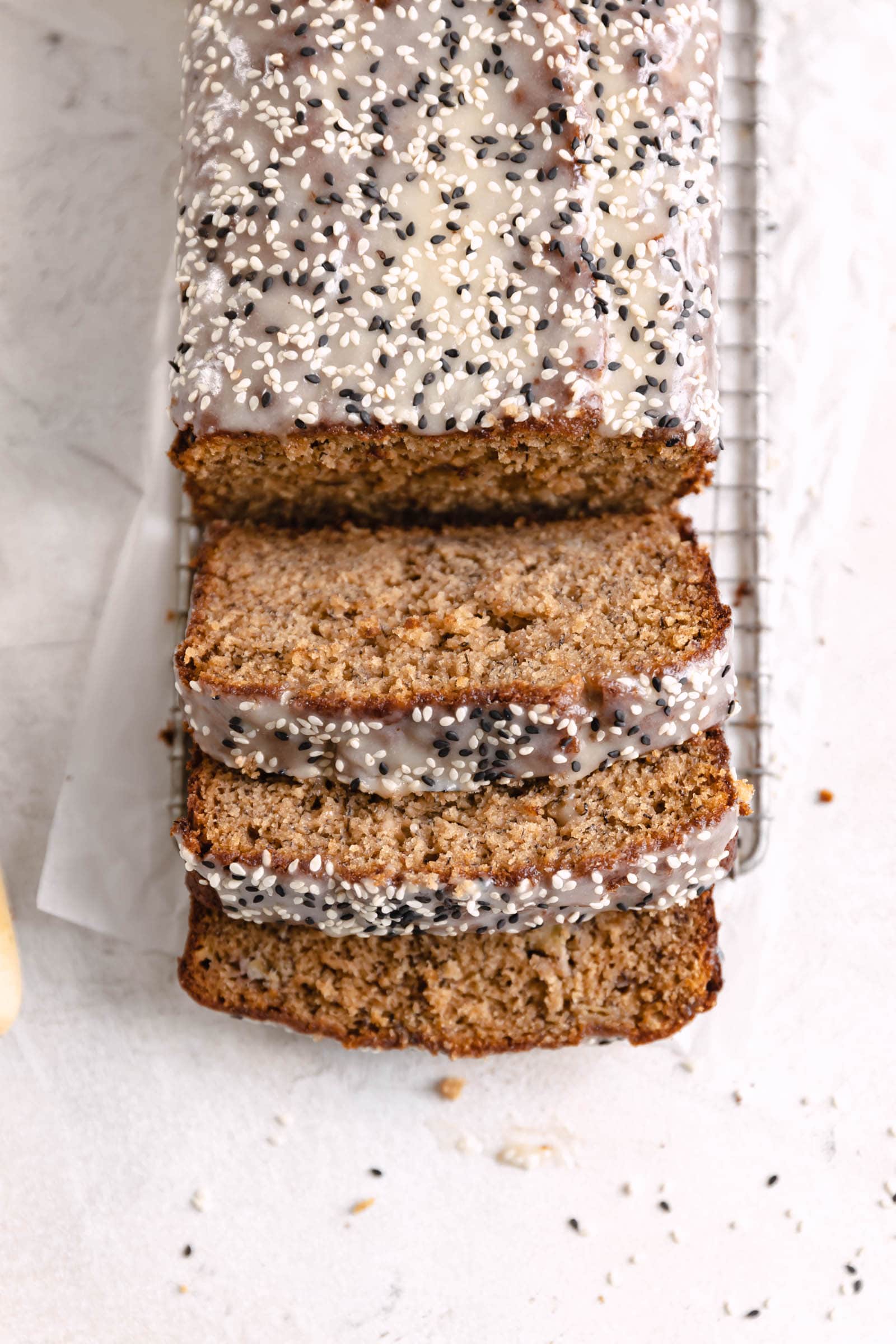 tahini banana bread topped with tahini glaze and sesame seeds