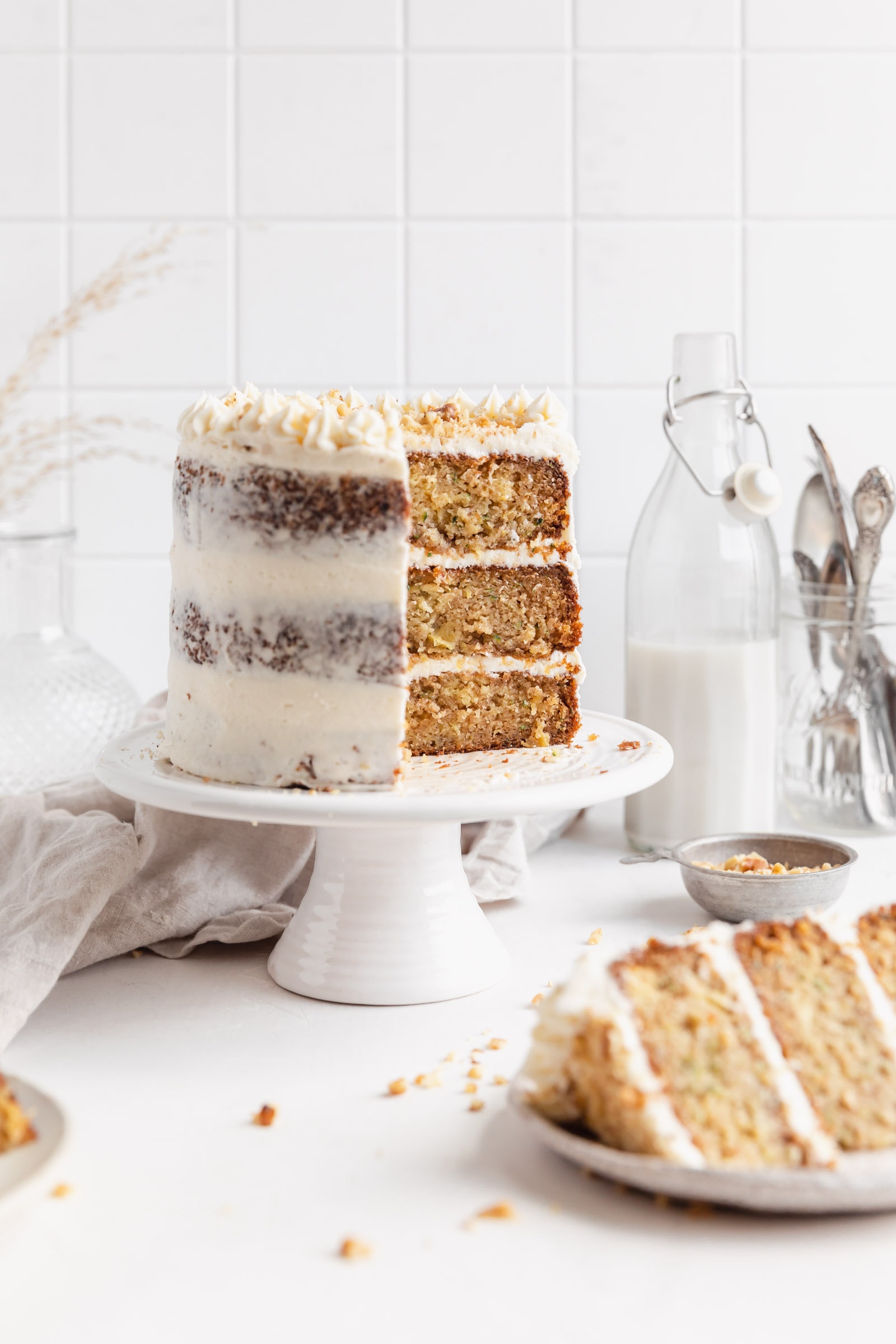 zucchini cake with cream cheese frosting on a cake stand