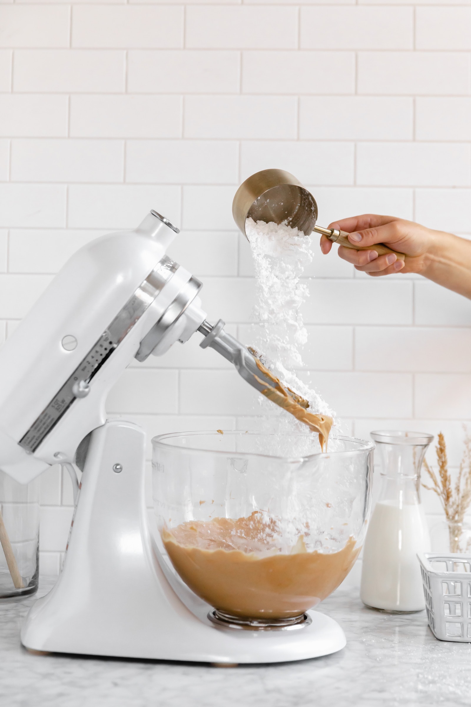 powdered sugar going into peanut butter frosting bowl