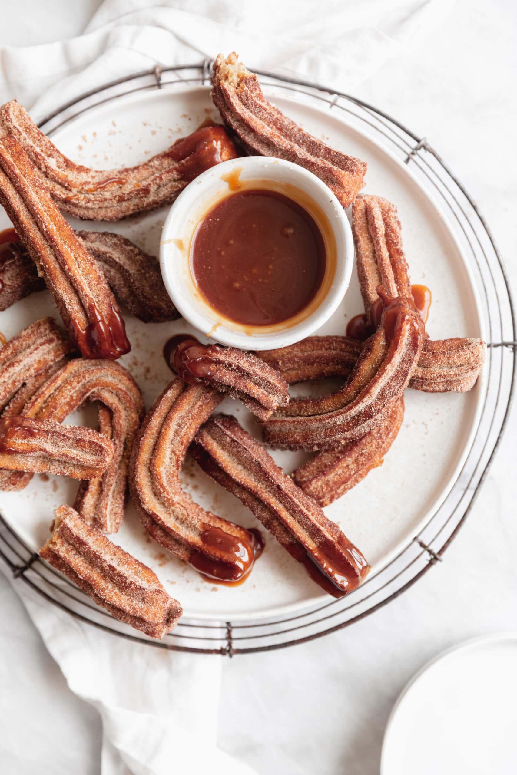 apple cider churros with caramel sauce in a cup