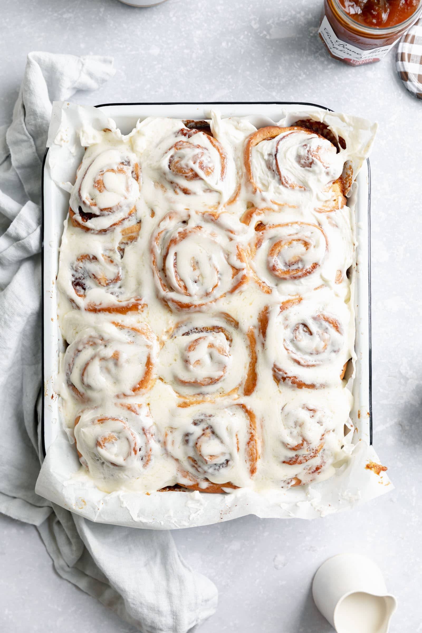 pumpkin cinnamon rolls with cream cheese icing in a pan