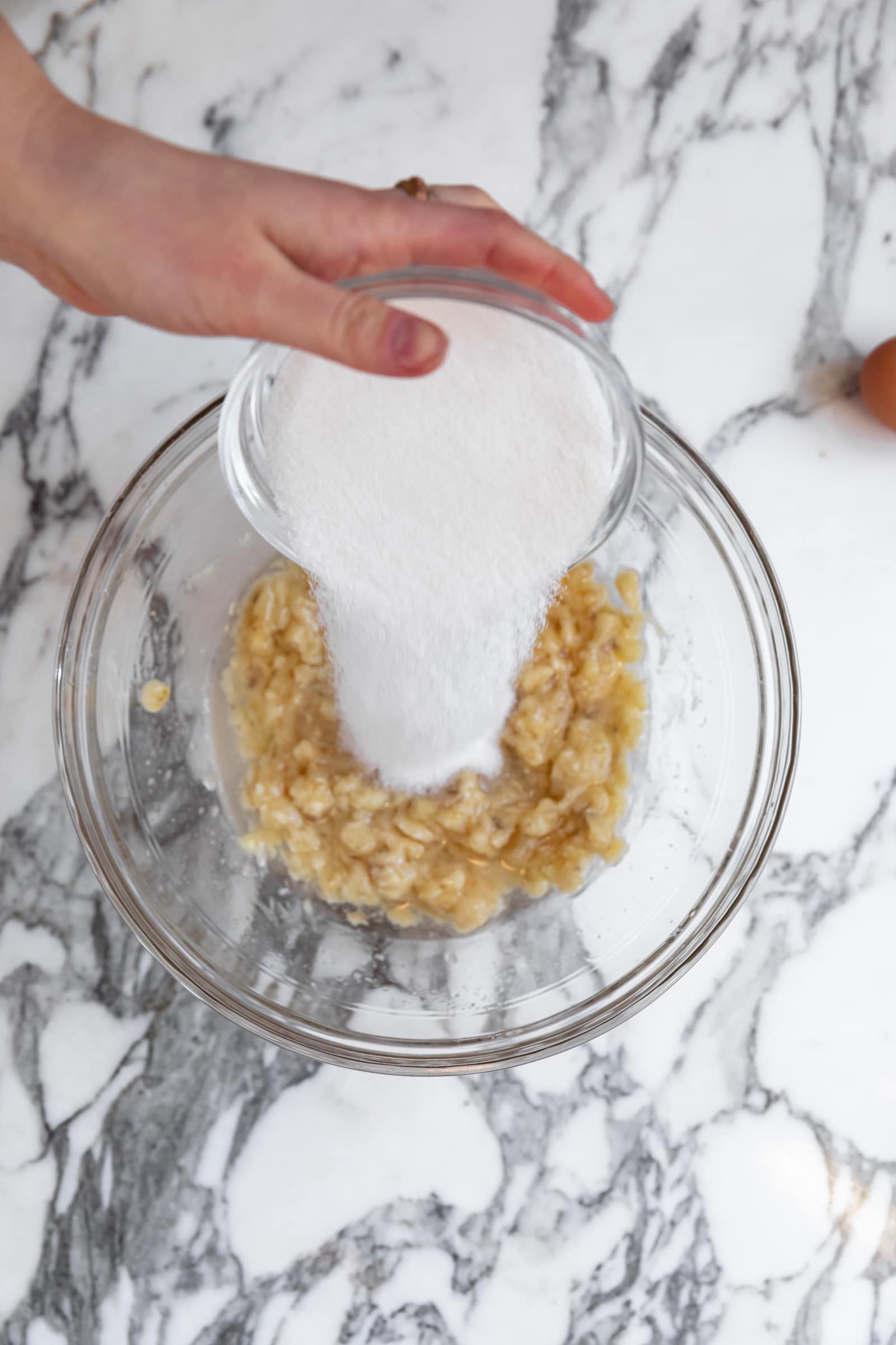 sugar pouring into banana bread batter