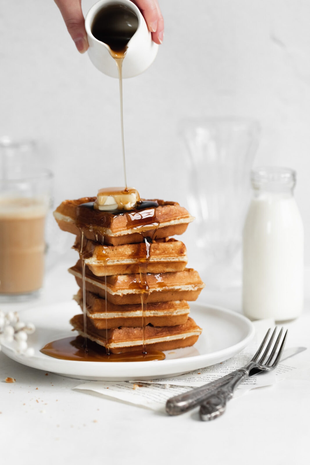 stack of homemade belgian waffles with butter and syrup