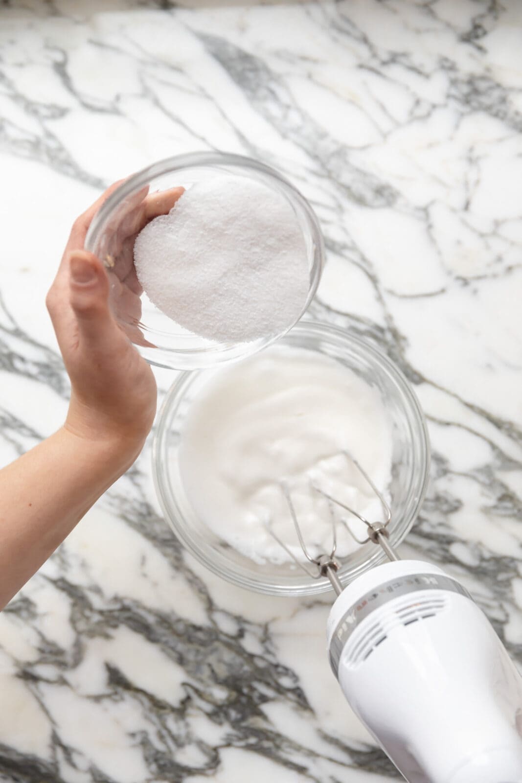 gradually pouring sugar into egg whites