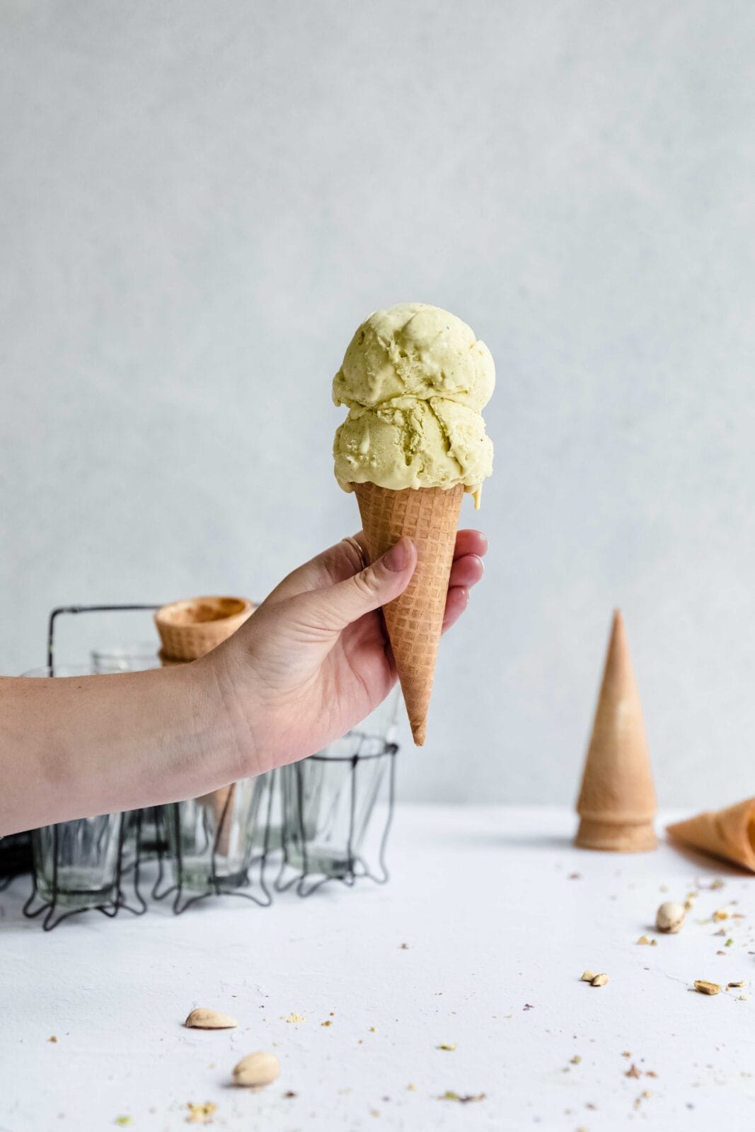 hand holding a cone with pistachio ice cream